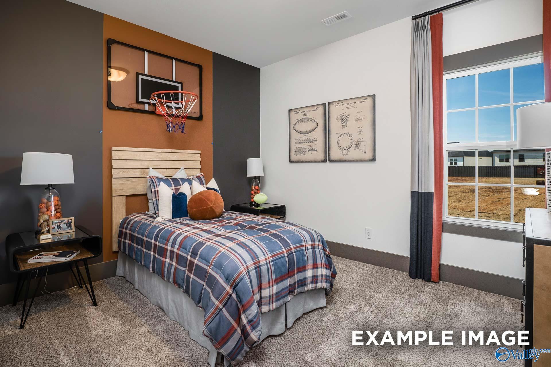 Boy's bedroom with basketball hoop, plaid bedding, orange accents, and sports art in Davidson Homes The Rockford B, Madison, Alabama