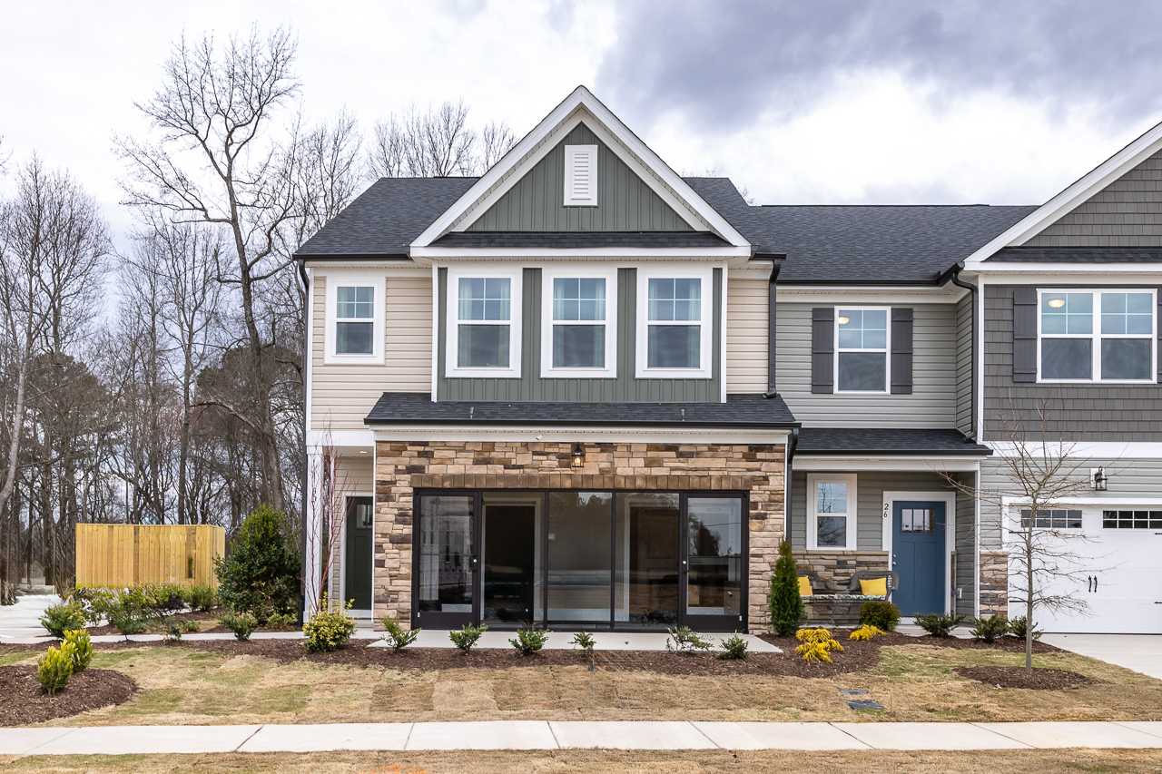 Modern townhome exteriors at Gregory Village Townhomes in Lillington NC with brick accents, large windows, and covered porches