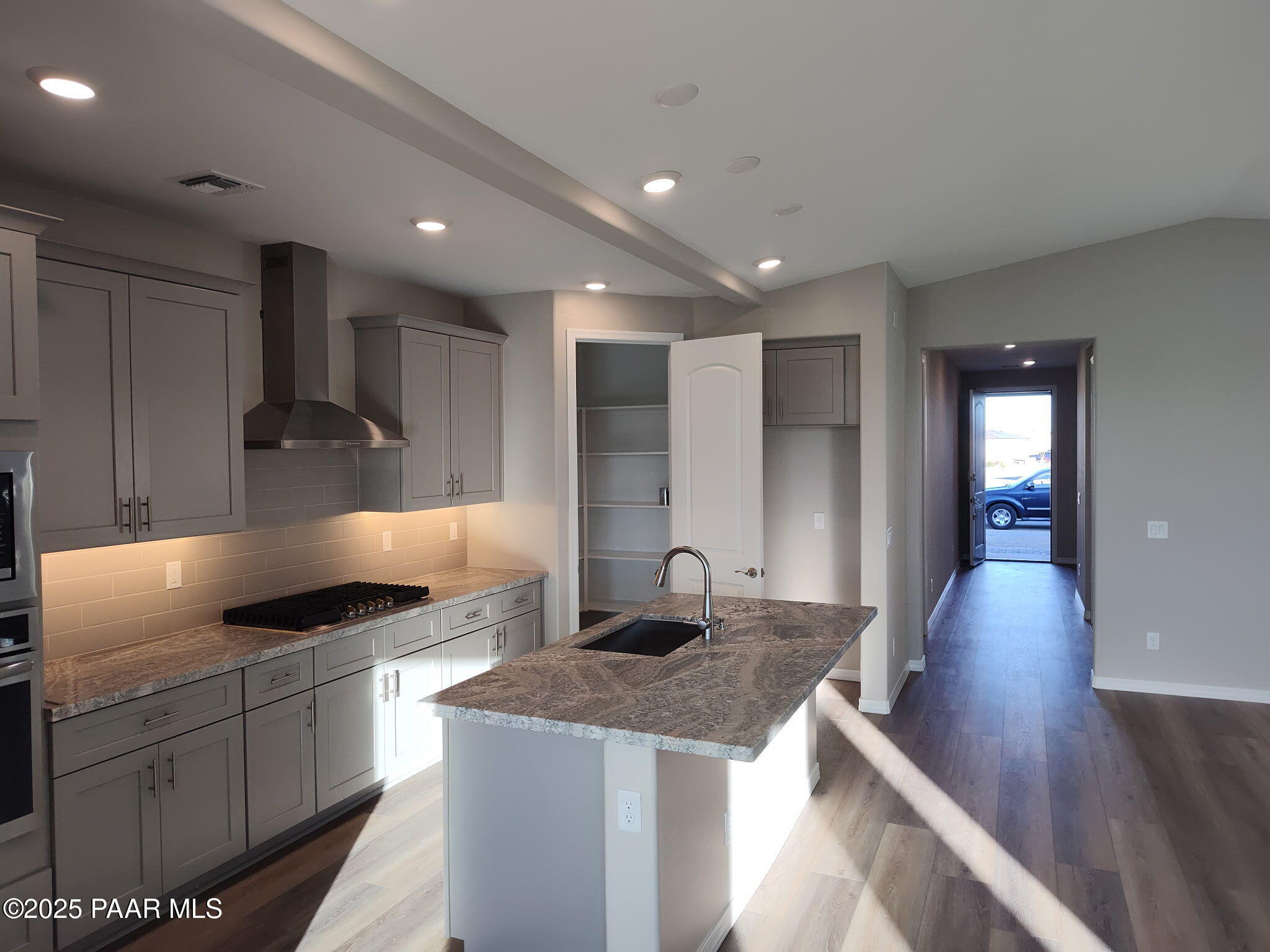 Modern open-concept kitchen with gray shaker cabinets, granite island sink, stainless appliances in Davidson Homes The Frontier C, Prescott Valley, AZ