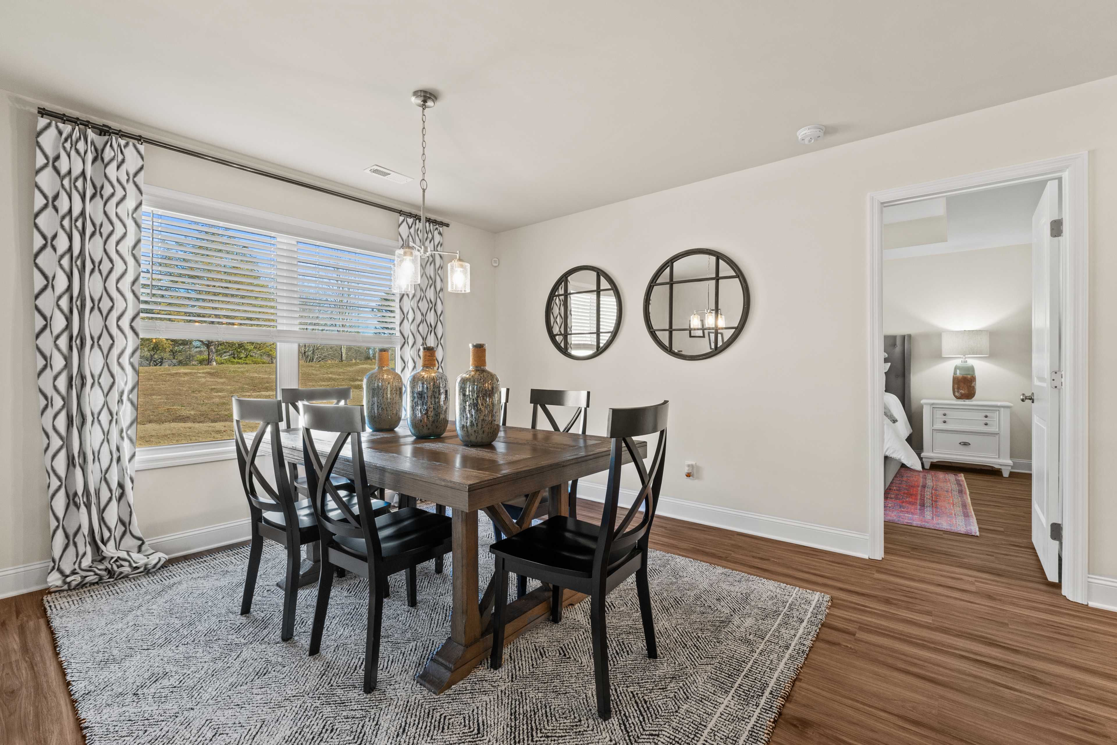 Spacious dining room at Ramsay Cove in Owens Cross Roads Alabama with wooden table black chairs pendant light and window views