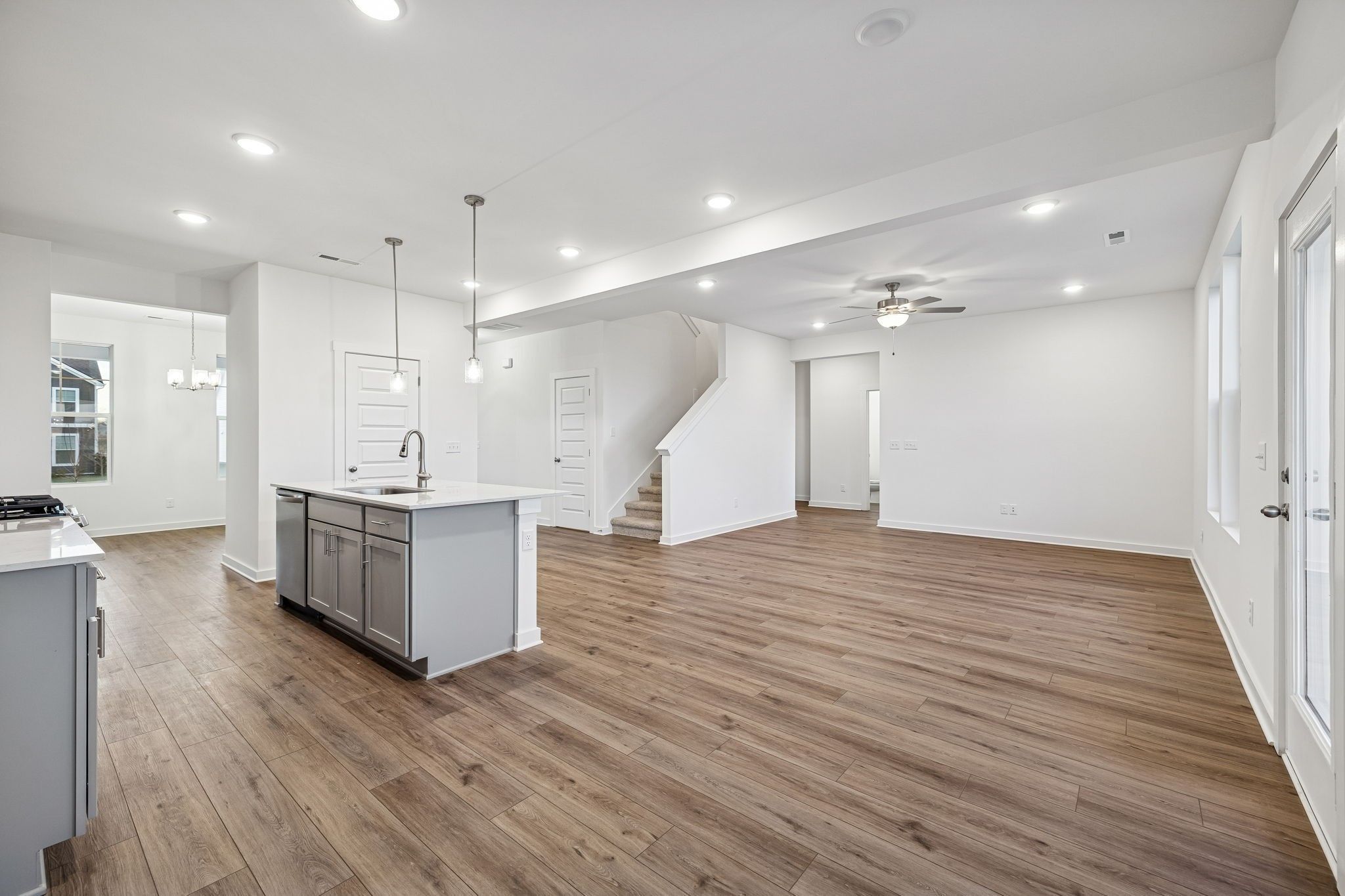 Open-concept kitchen island with white quartz counters and hardwood floors in Davidson Homes The Willow, Calista Farms, White House, TN
