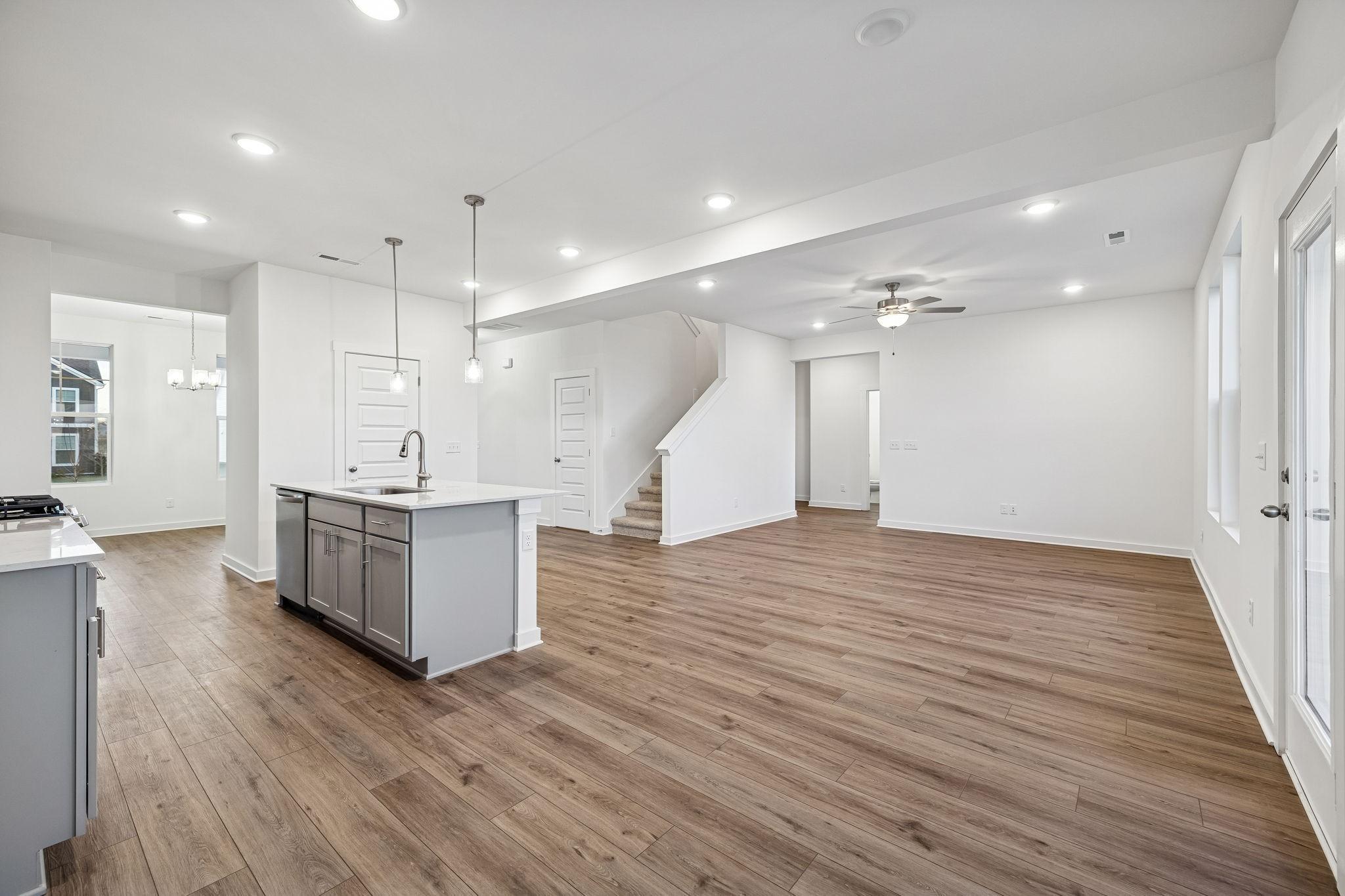 Open-concept kitchen island with white quartz counters and hardwood floors in Davidson Homes The Willow, Calista Farms, White House, TN