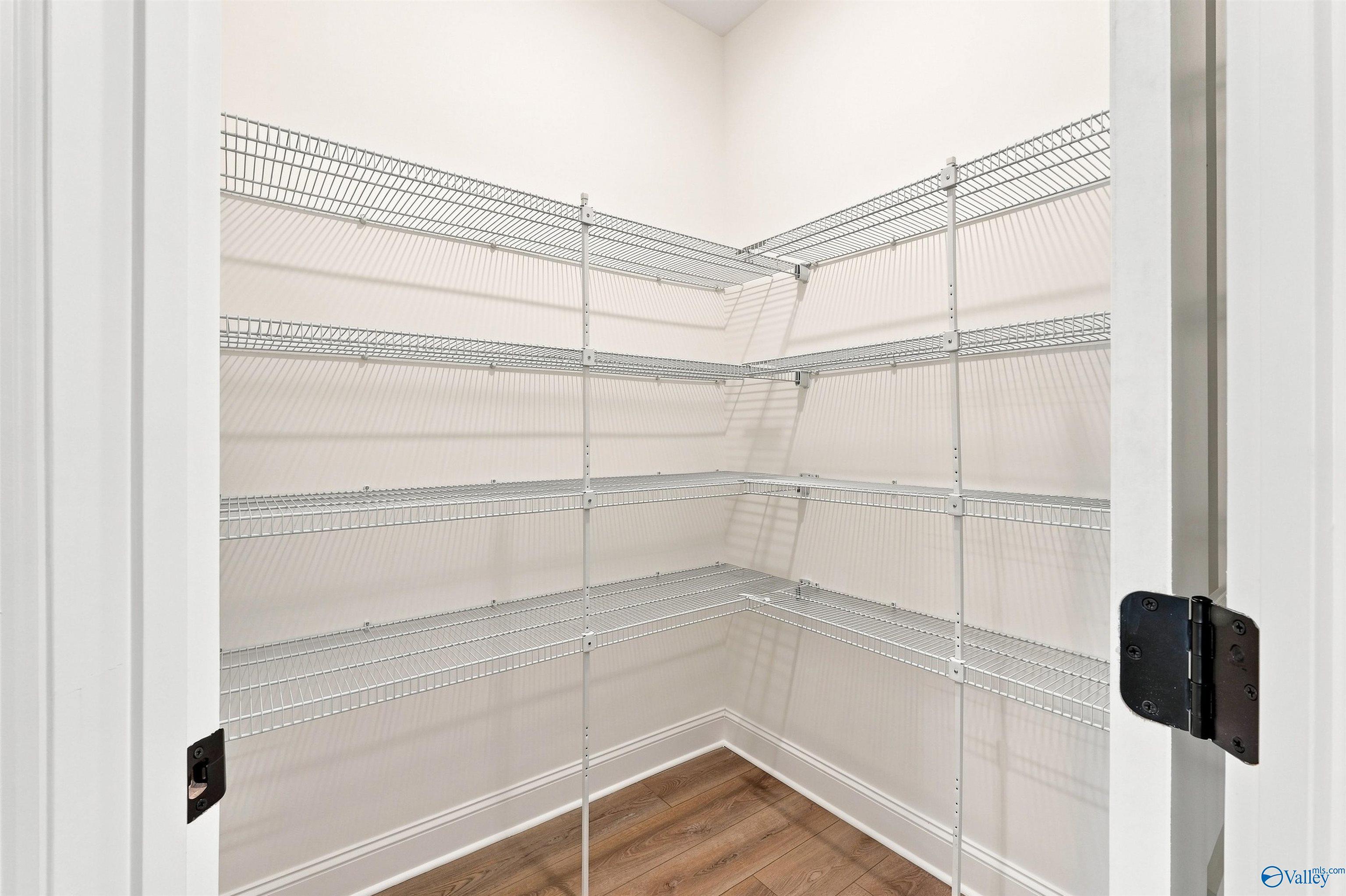 Walk-in pantry with white wire shelving in The Oxford floor plan at Kendall Farms, Toney, Alabama.