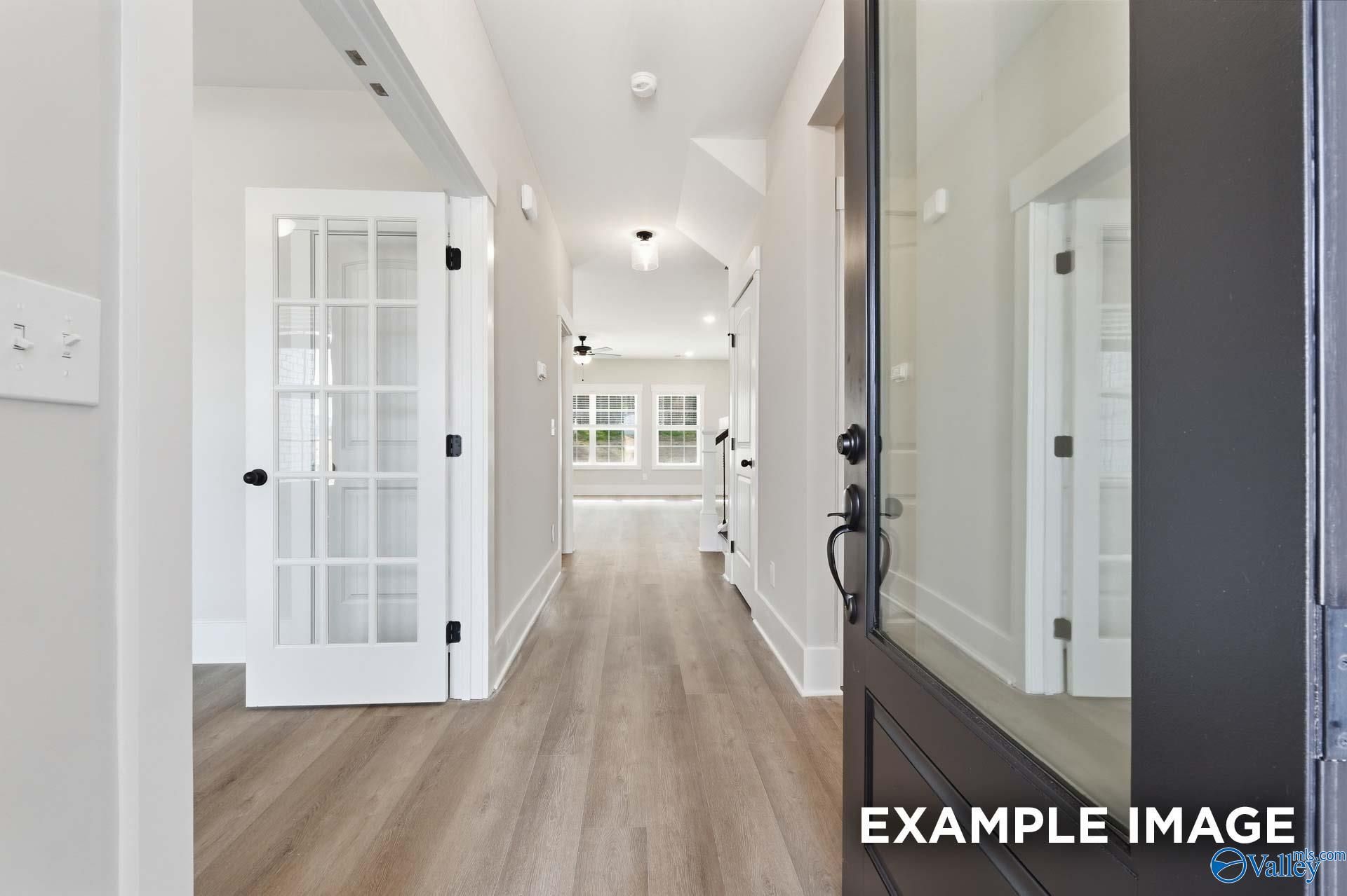 Bright entryway with French doors and modern flooring in The Rockford floor plan by Davidson Homes in Briercreek.