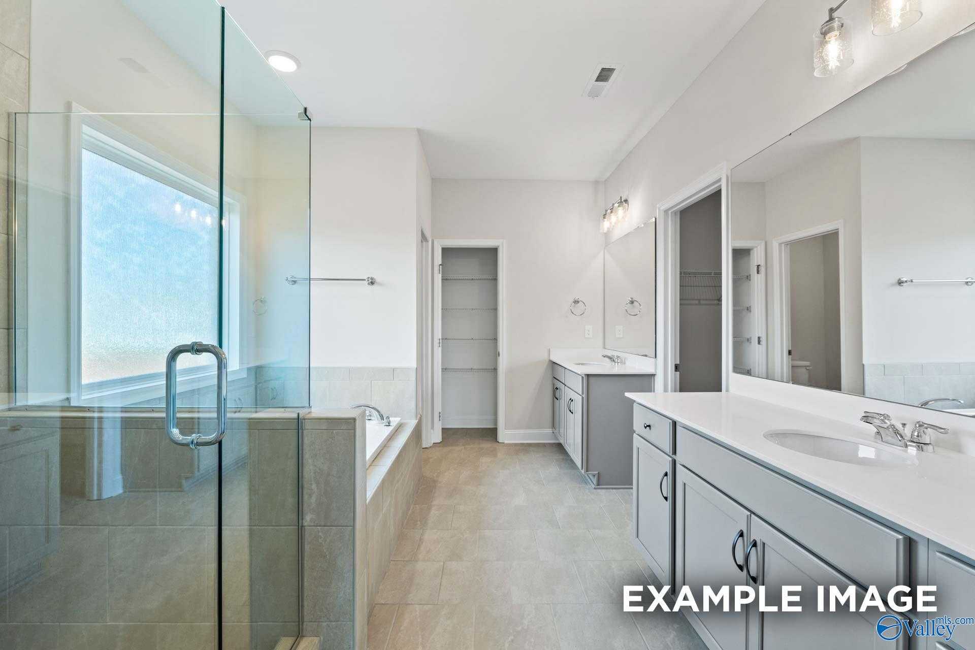 Luxurious master bathroom featuring frameless glass shower, soaking tub, double vanity in Davidson Homes The Lanier, Toney, Alabama