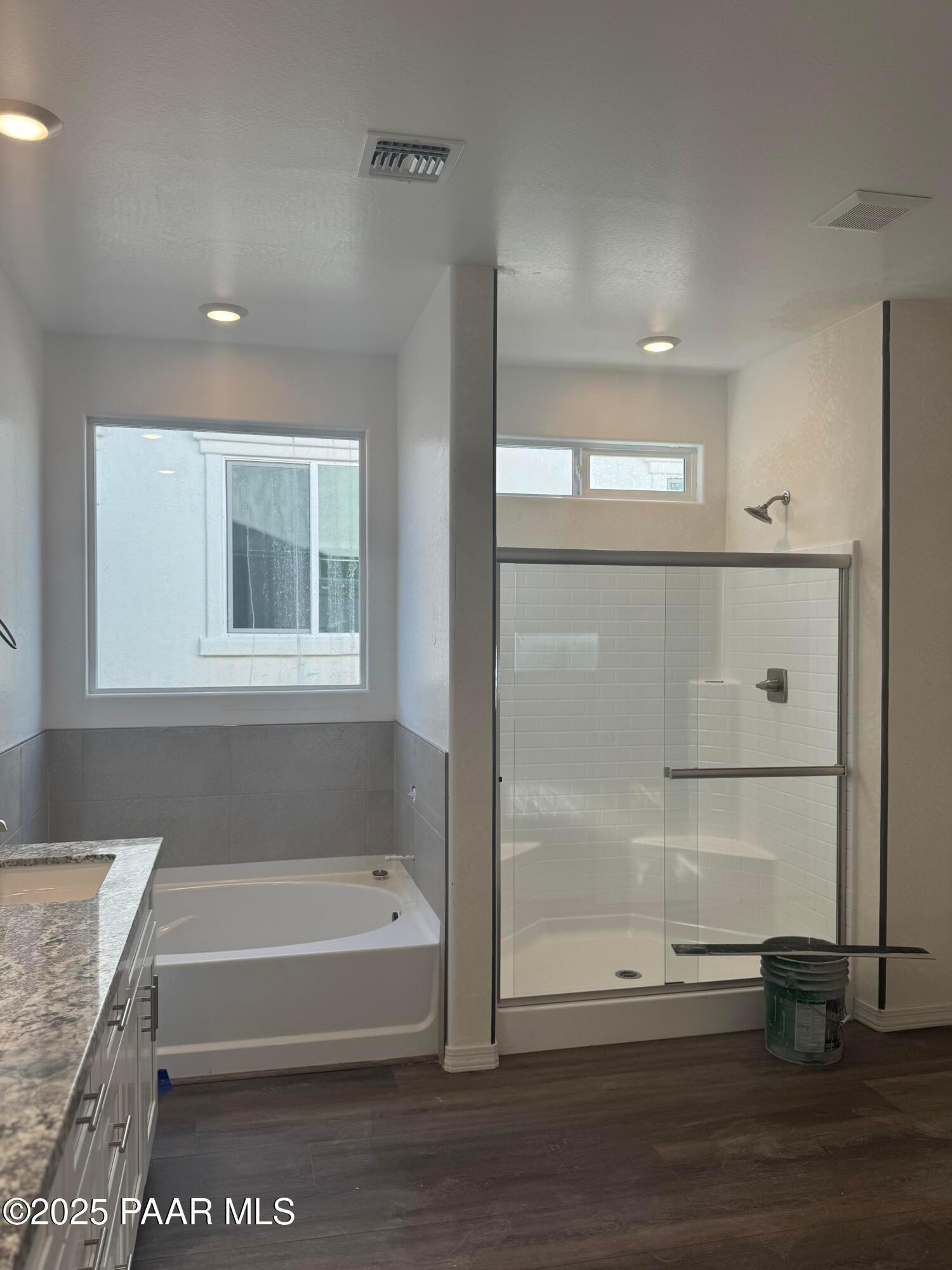 Modern master bathroom featuring soaking tub, glass walk-in shower, and quartz vanity in Davidson Homes The Summit A, Prescott, AZ
