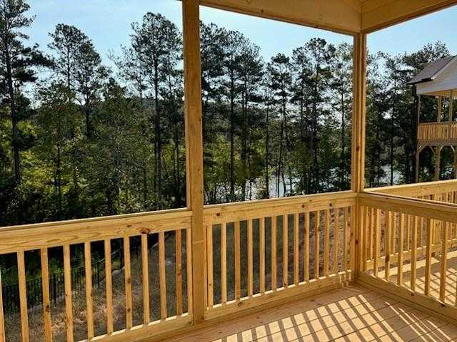 Elevated wooden deck overlooking pine forest and serene lake in The Hickory A, Riverwood, Dallas, Georgia