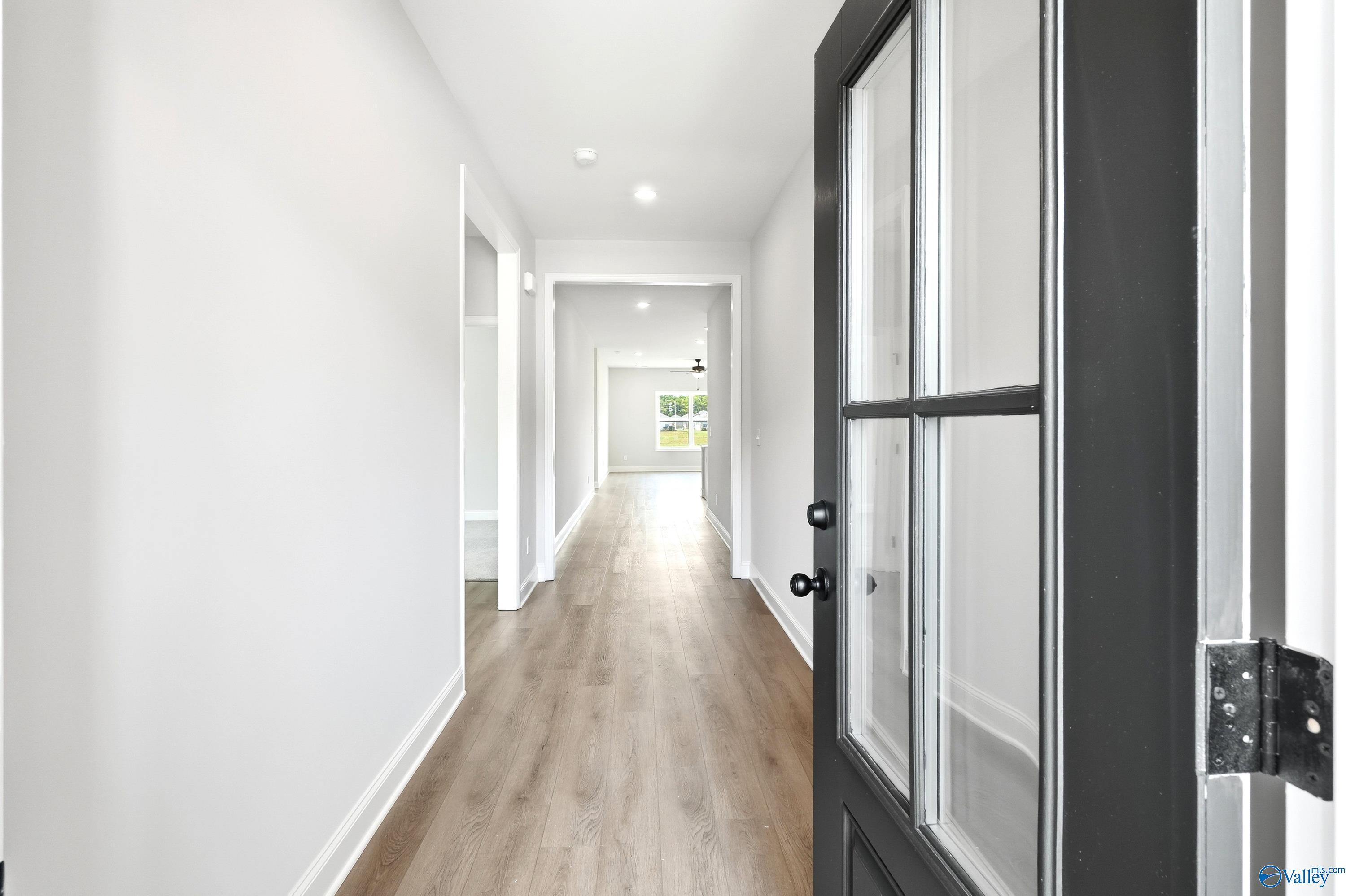 Bright foyer and hallway with luxury vinyl plank flooring in The Daphne floor plan at Lynn Meadows, Meridianville, AL.