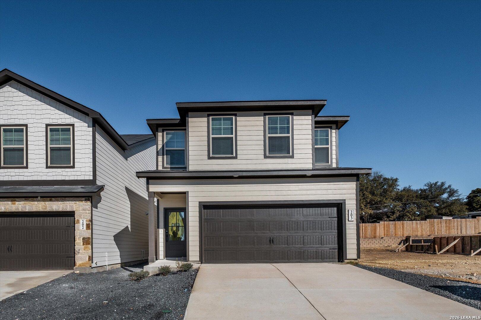 Modern 2-story Charlotte A home with gray siding, stone accents, and 2-car garage in Meadows at Oak Creek, San Antonio, Texas