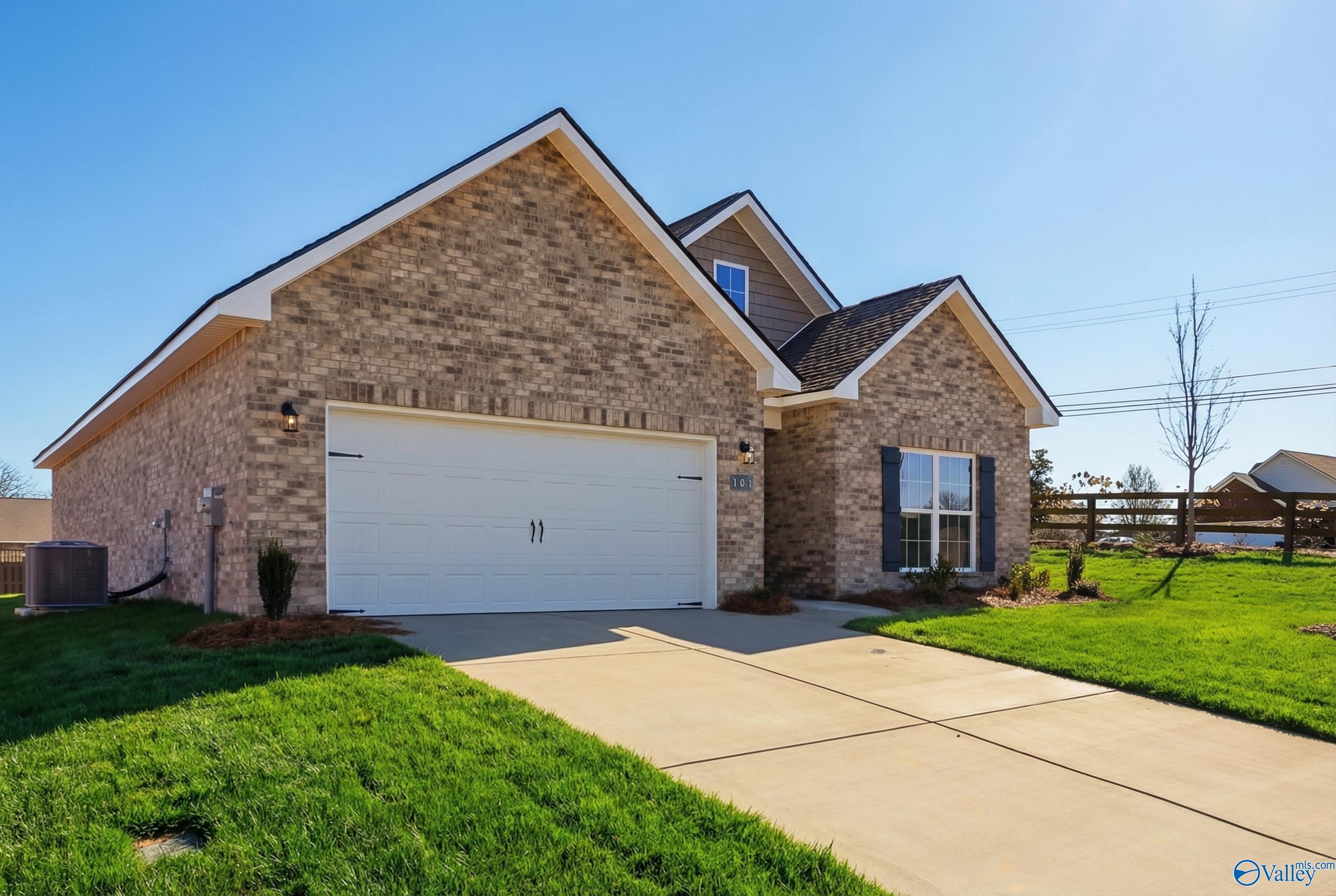 Brick single-story home with 2-car garage, driveway, and lush green lawn in Flint Meadows, New Market, Alabama by Davidson Homes