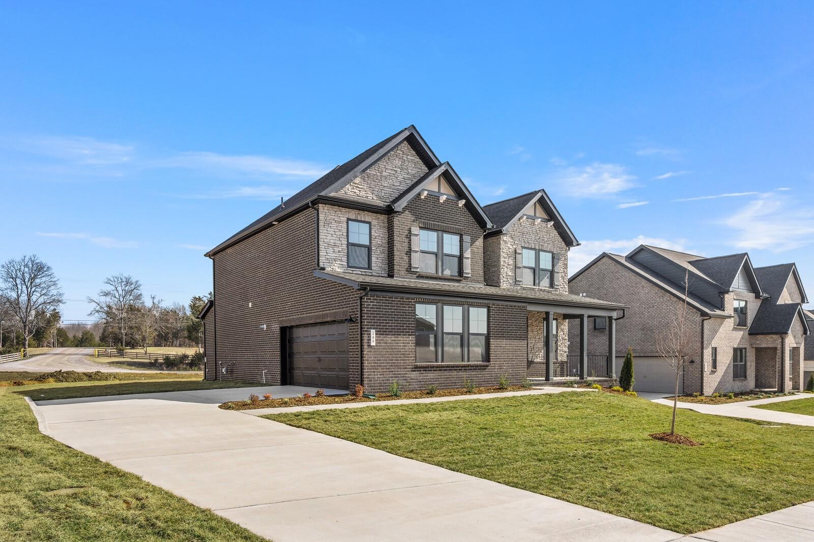 Two-story brick Davidson Homes Willow D with 2-car garage, front porch, and landscaped yard in Benders Cove, Mt. Juliet, TN