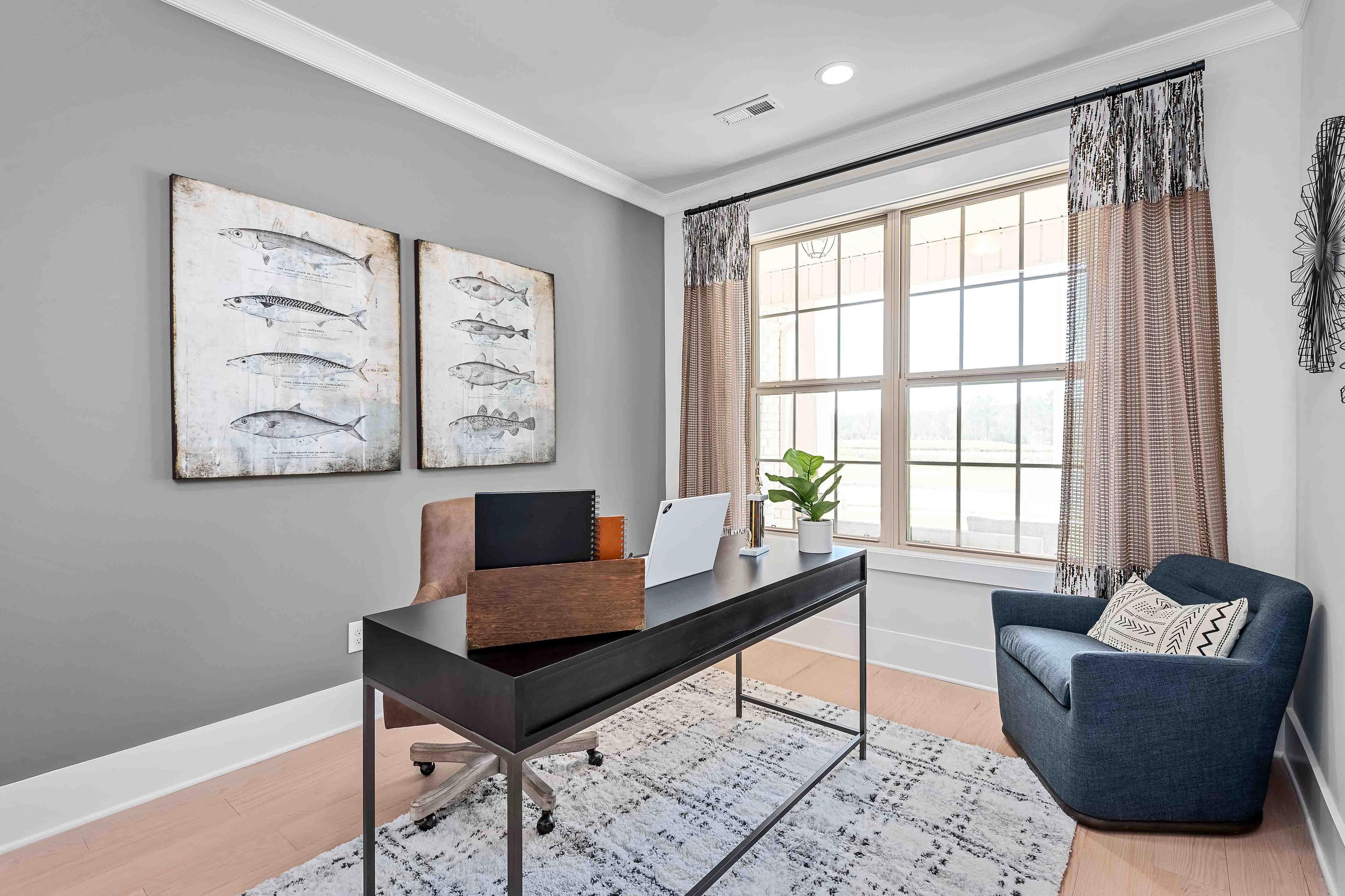 Cozy home office at Cain Park in Hartselle Alabama with black desk, large windows, potted plant, and nautical fish wall art