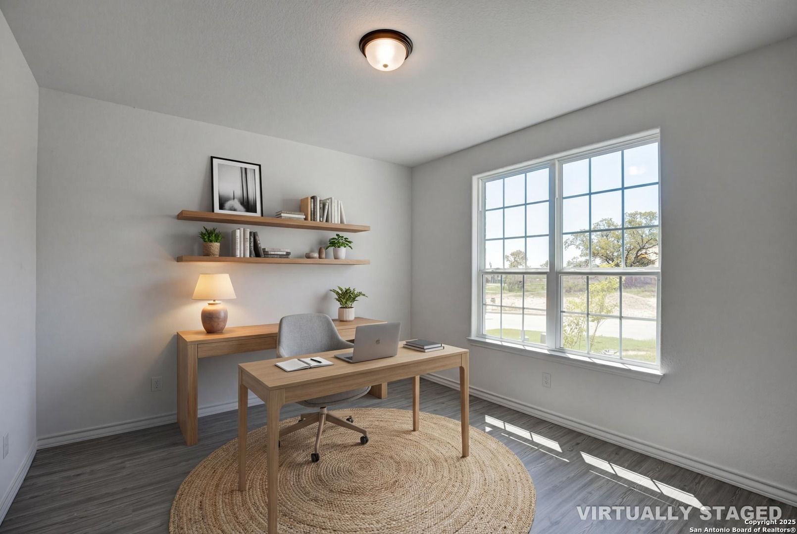Cozy home office with wooden desk, ergonomic chair, floating shelves, plants, and large window in Davidson Homes The Garner B, Castroville, Texas