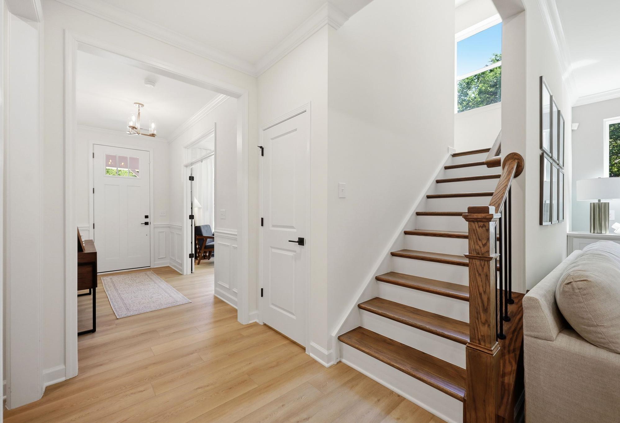 Bright foyer and staircase in The Aspen by Davidson Homes, featuring hardwood floors and elegant trim details.