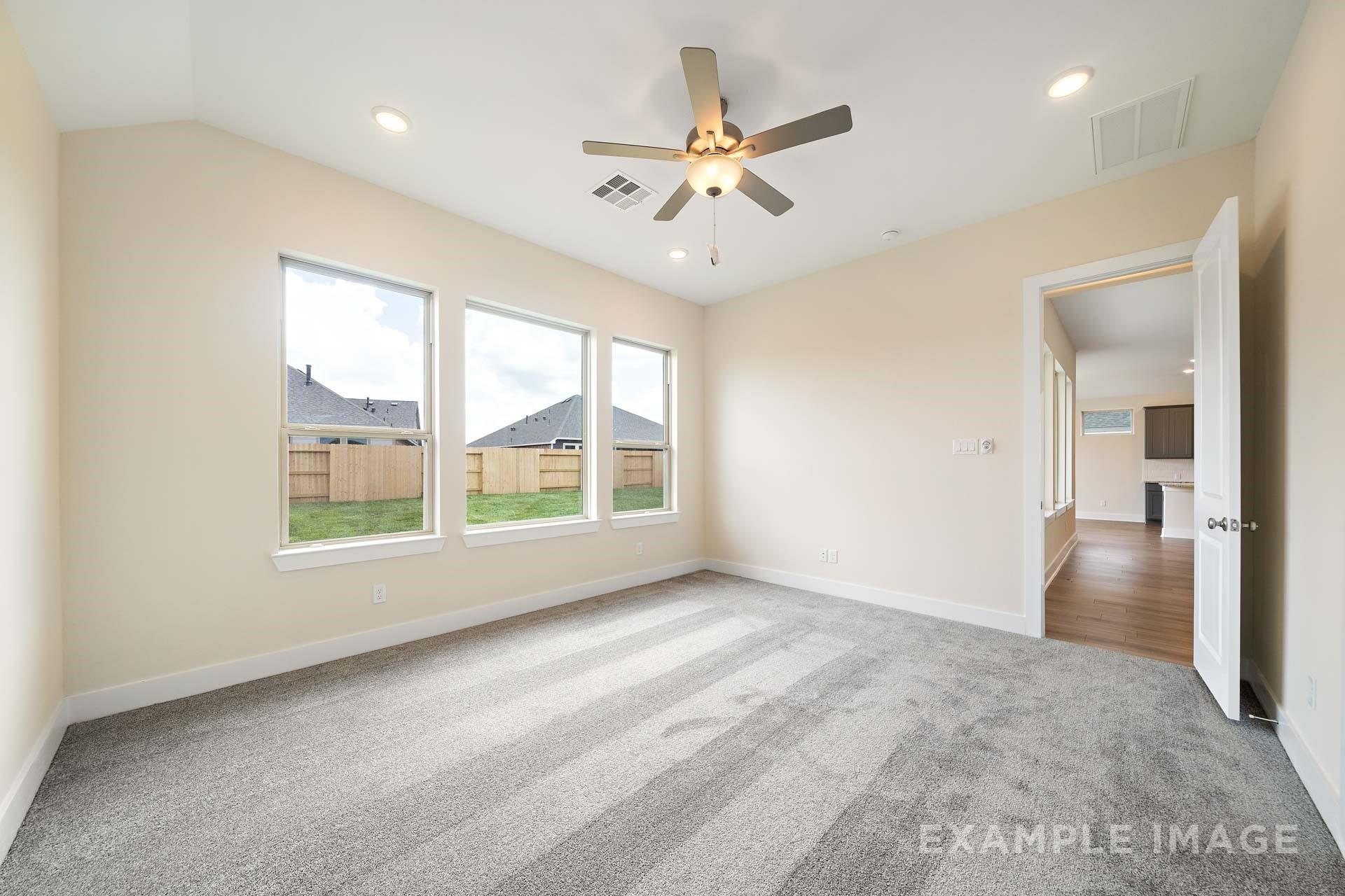 Bright bedroom with ceiling fan, carpet flooring, and backyard views in Davidson Homes The Diana C at Lago Mar, Texas City