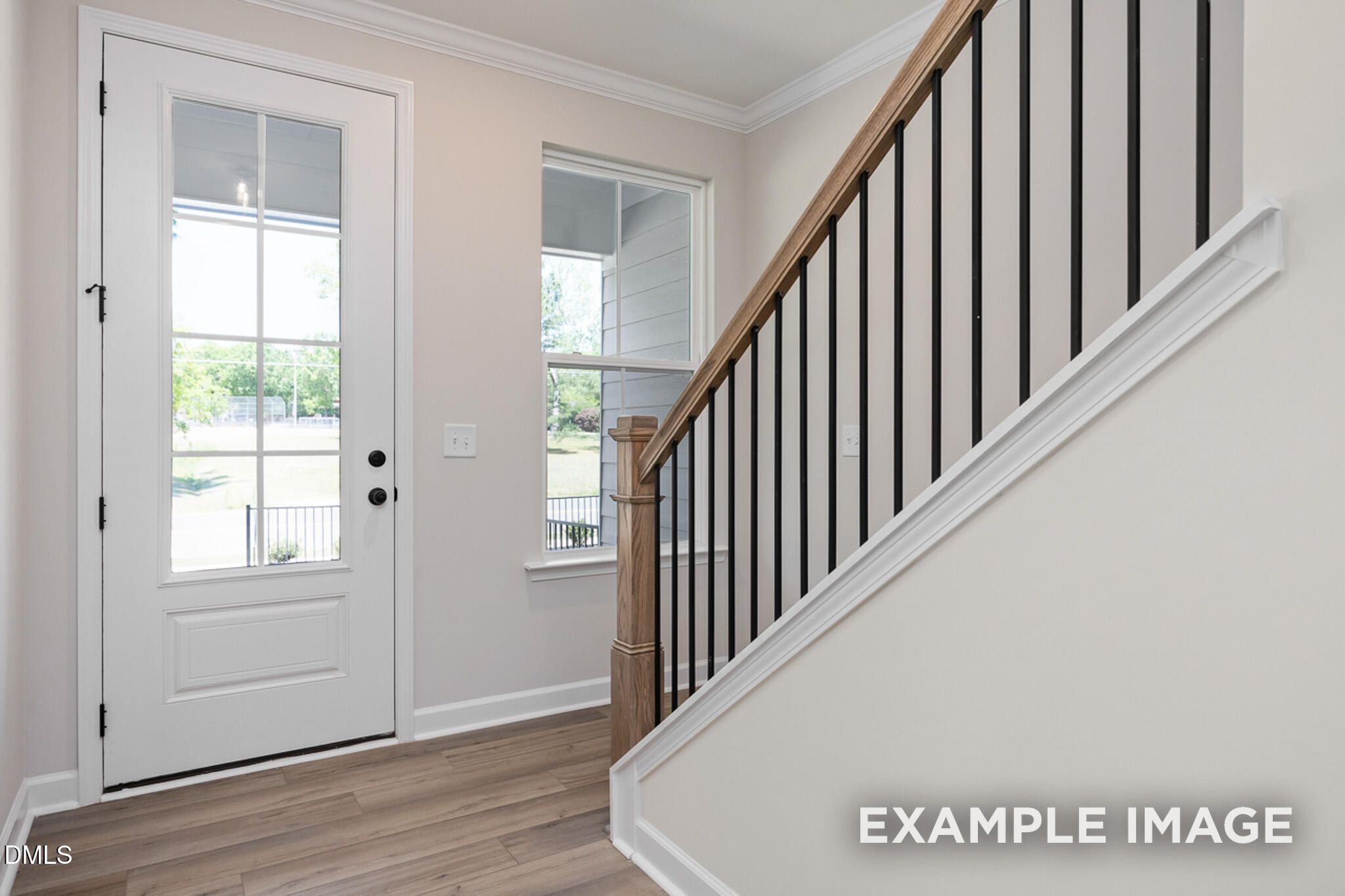 Bright entryway with modern staircase and wooden handrail in The Mitchell floor plan at Camden Park, Knightdale, NC.