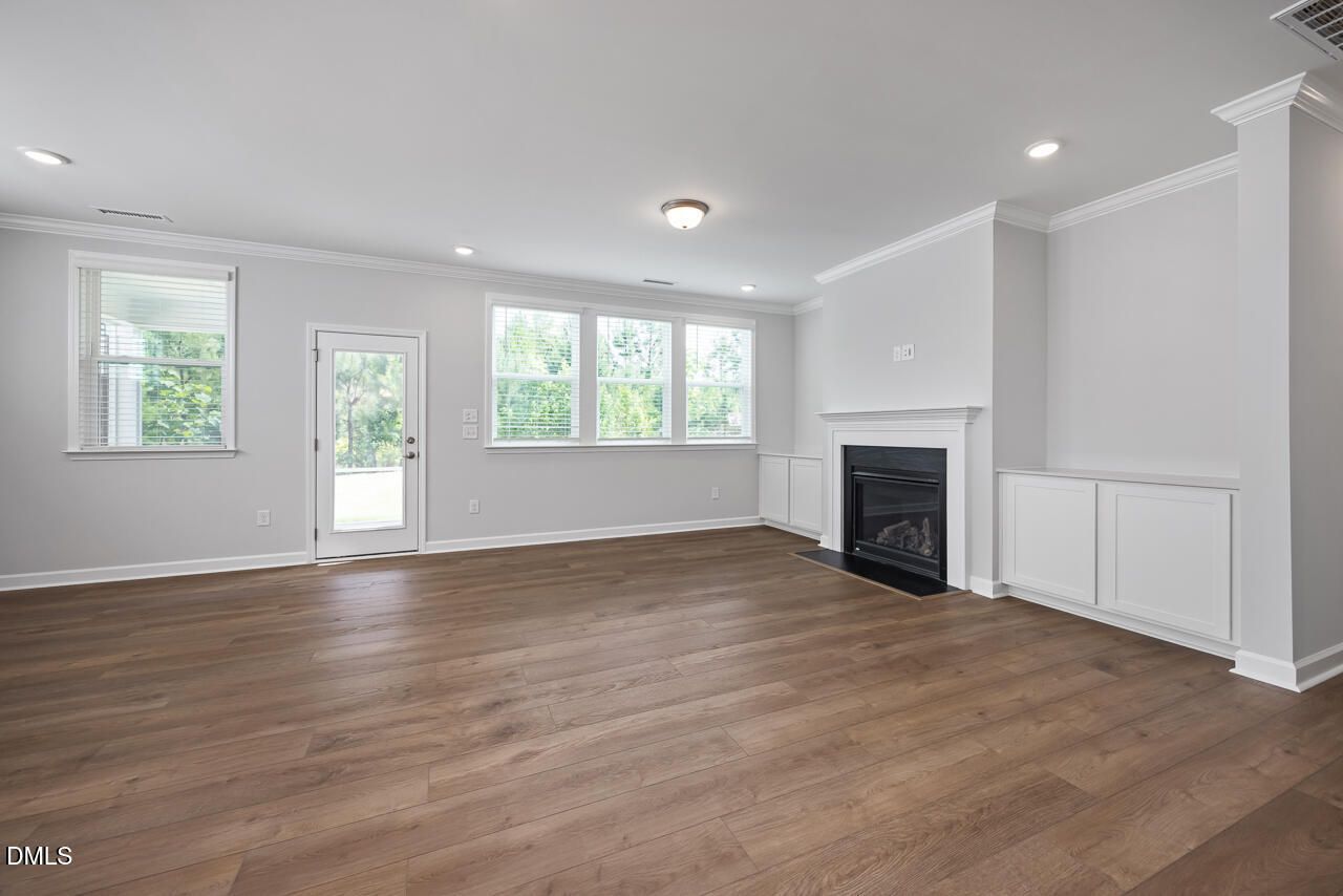 Spacious living room with fireplace and custom built-ins in The Ashport L floor plan, Sage on North Main, Wake Forest, NC.