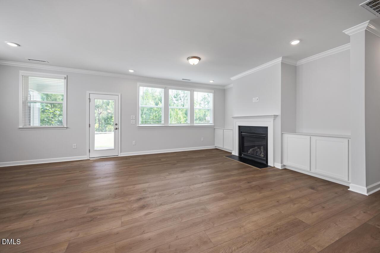 Spacious living room with fireplace and custom built-ins in The Ashport L floor plan, Sage on North Main, Wake Forest, NC.