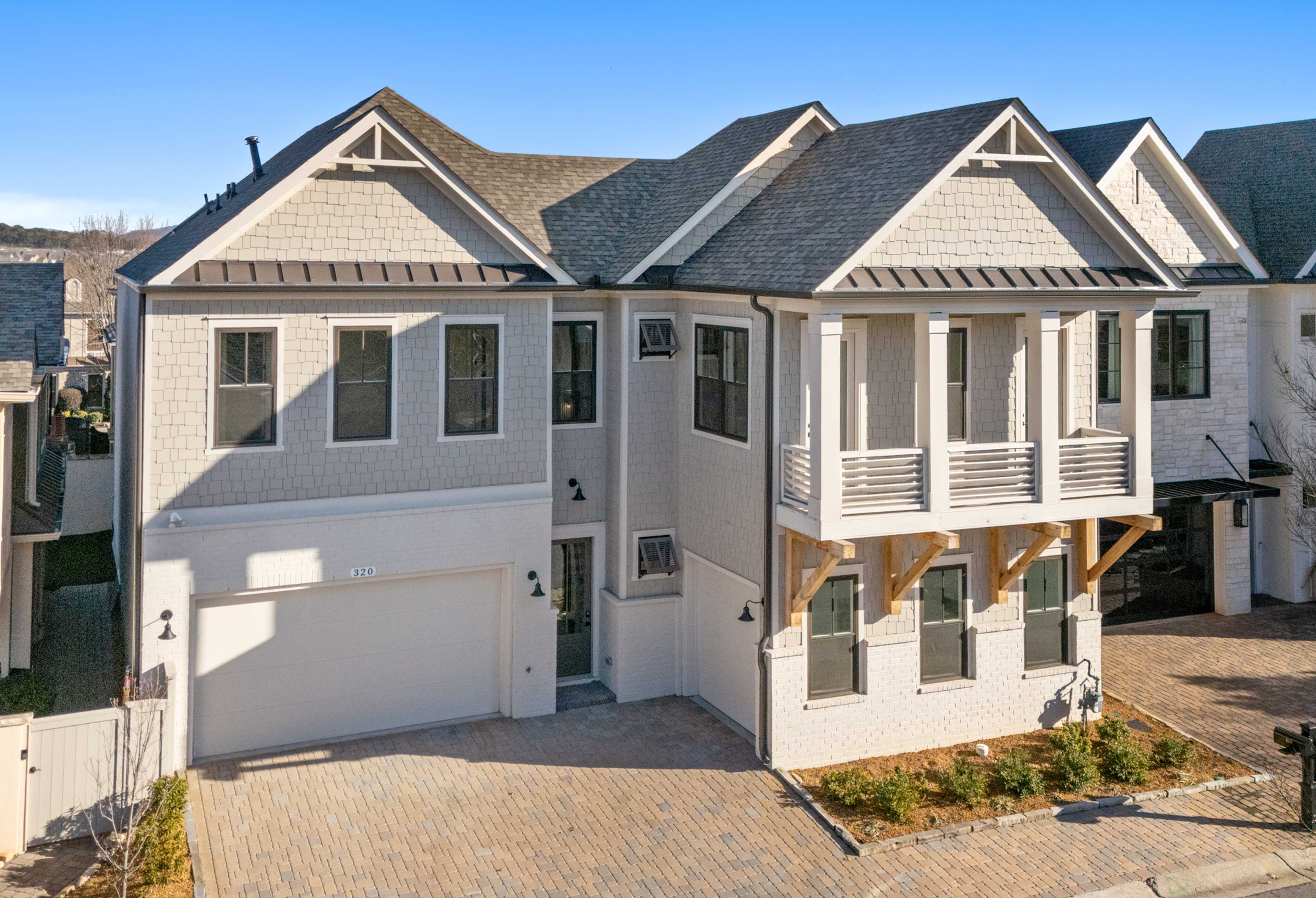 Two-story The Seaside home elevation by Davidson Homes in Woodstock, GA: white siding, dark gable roof, three-car garage, upper balcony