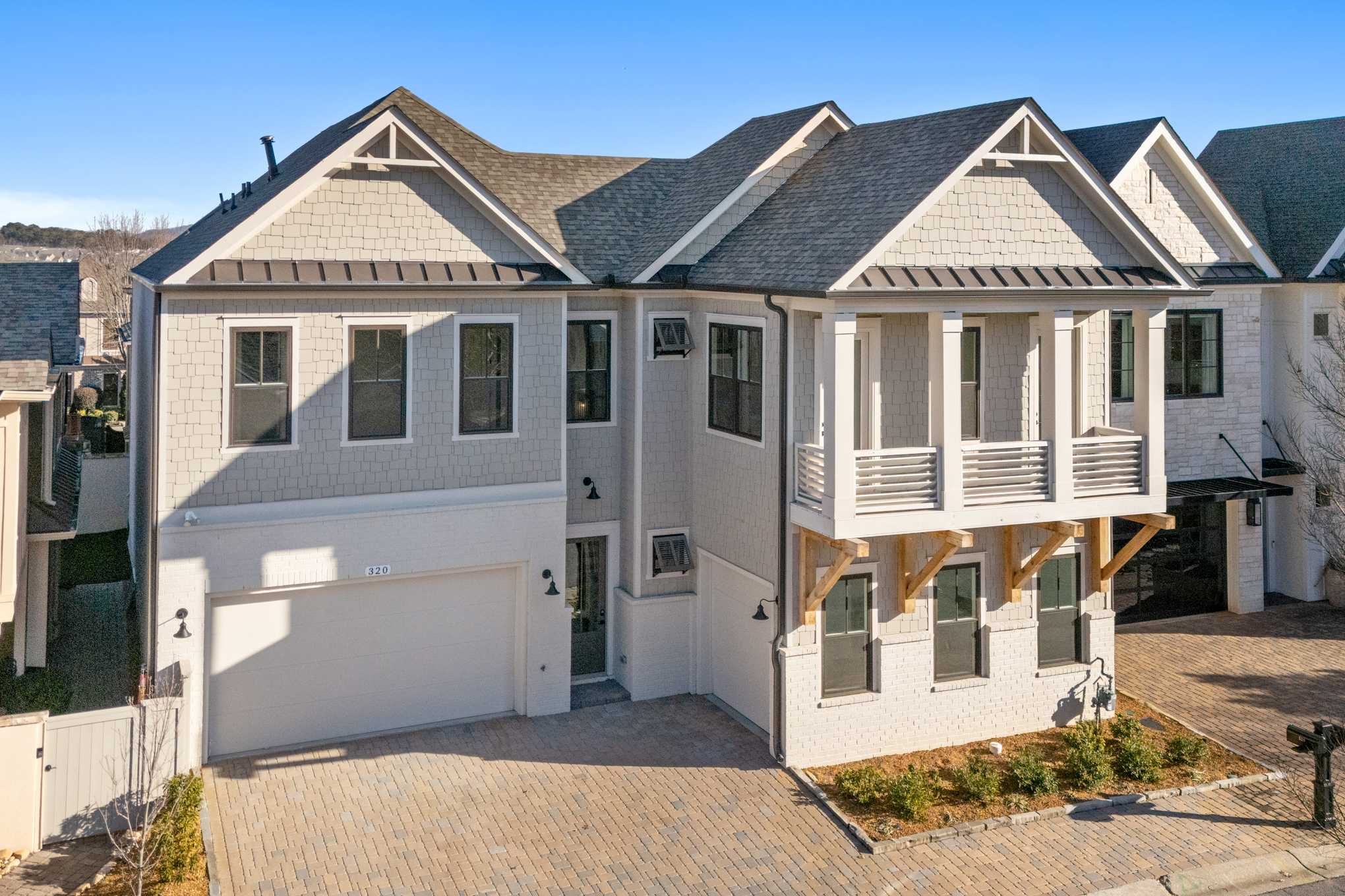 Two-story The Seaside home elevation by Davidson Homes in Woodstock, GA: white siding, dark gable roof, three-car garage, upper balcony