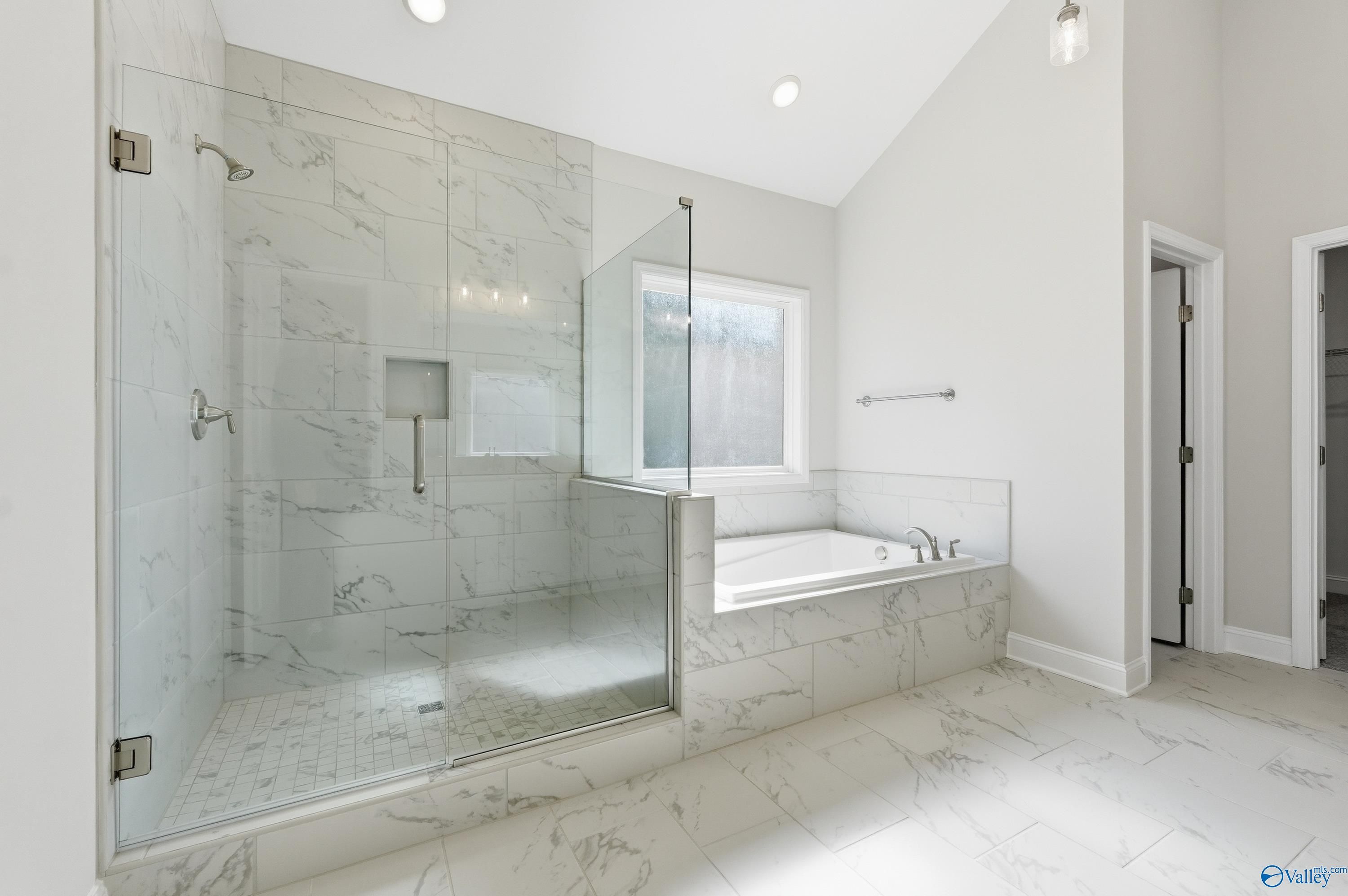 Elegant master bathroom with marble glass shower and freestanding tub in Davidson Homes The Finleigh, Harvest, AL