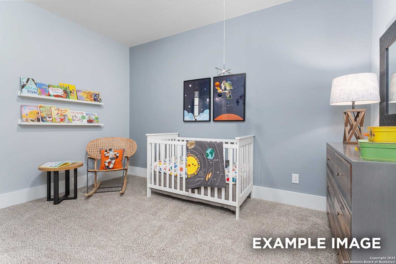 Charming space-themed nursery with blue walls, solar system crib, bookshelves, and rocker in Davidson Homes The Daphne H, Seguin, Texas