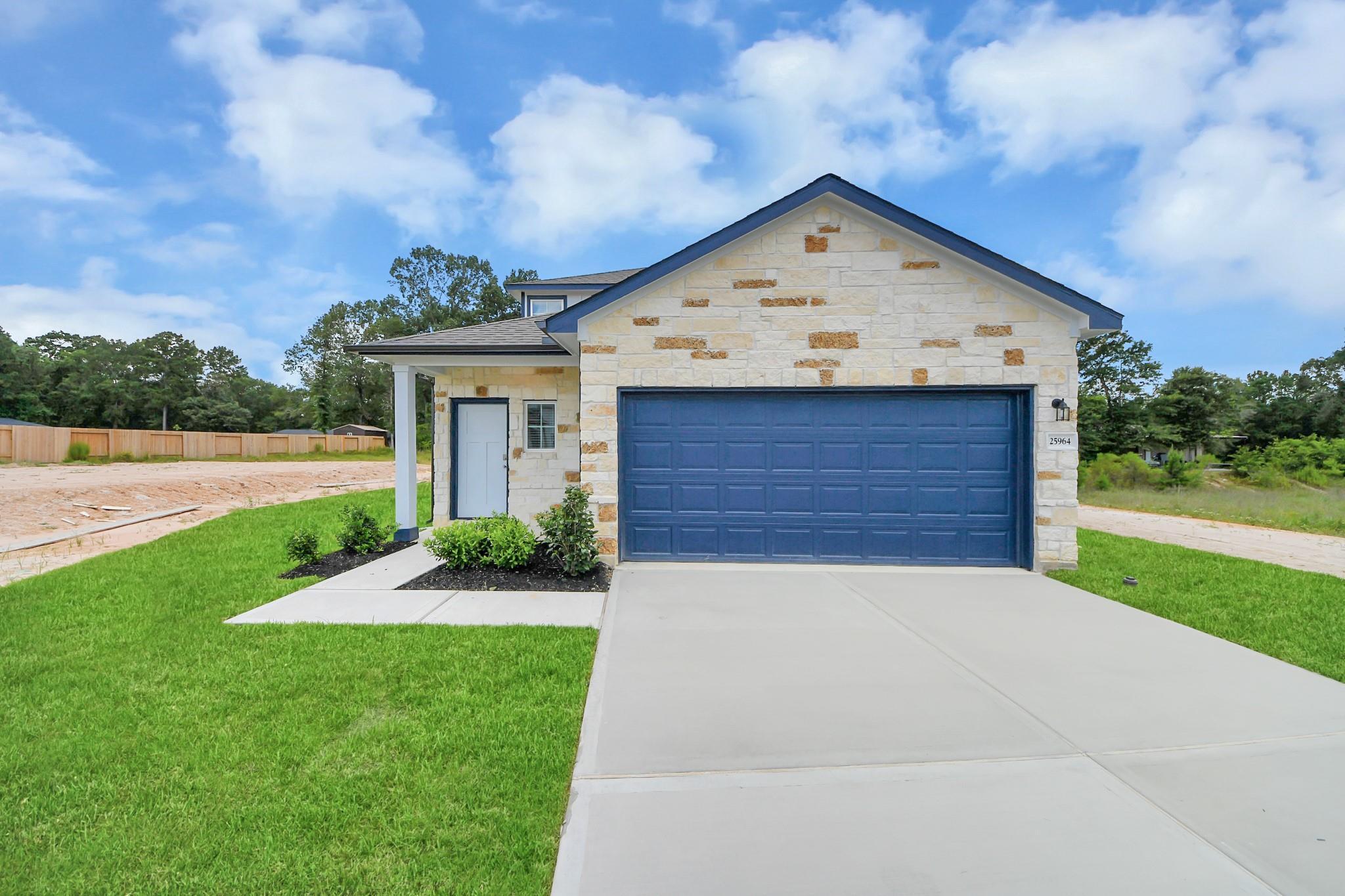 Stone exterior facade of The Sabine E floor plan by Davidson Homes with a 2-car garage in Liberty Estates, Cleveland, Texas.