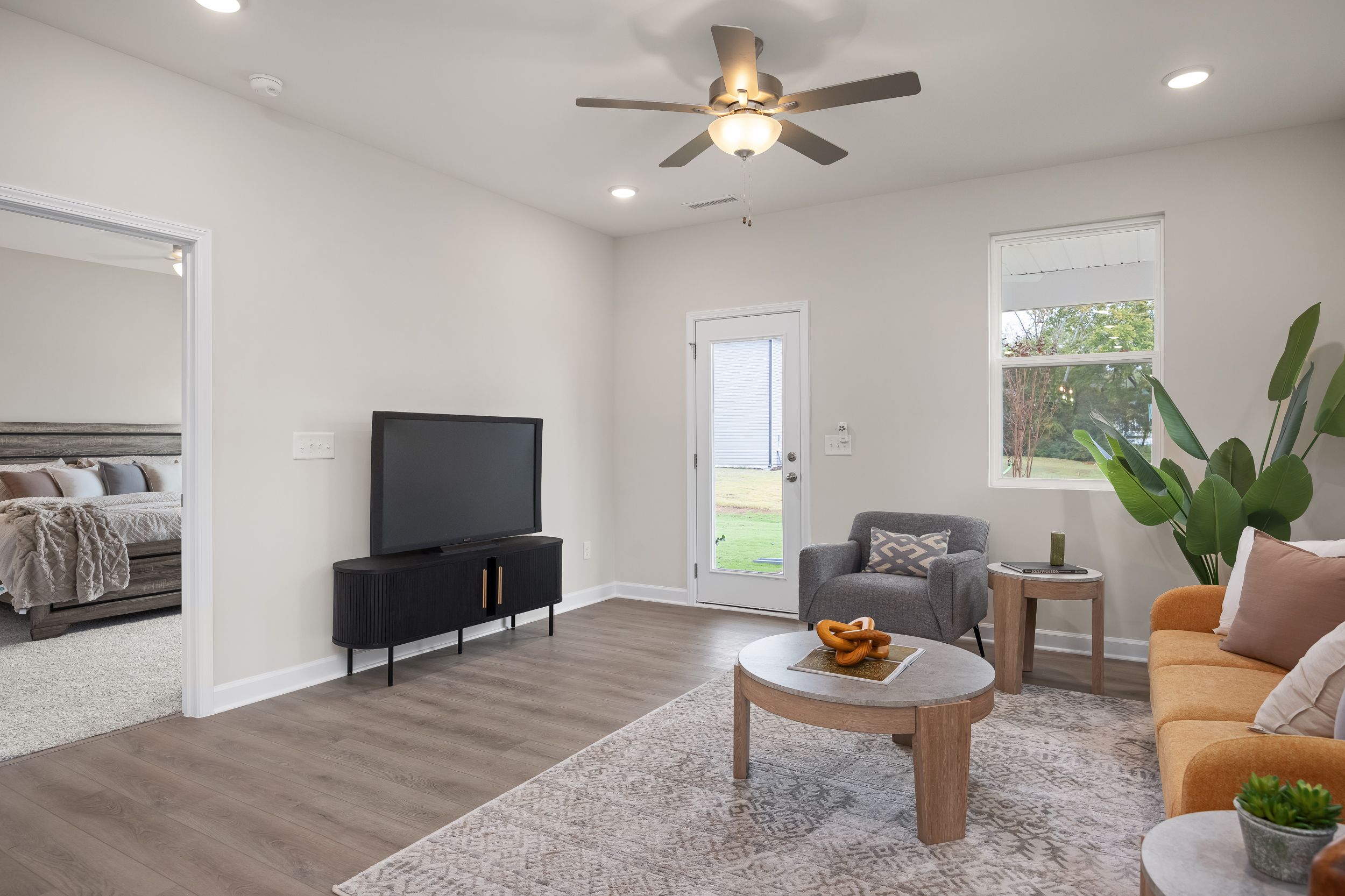 Modern living room at Gregory Village in Lillington, NC by Davidson Homes with wood floors, area rug, and stylish decor.