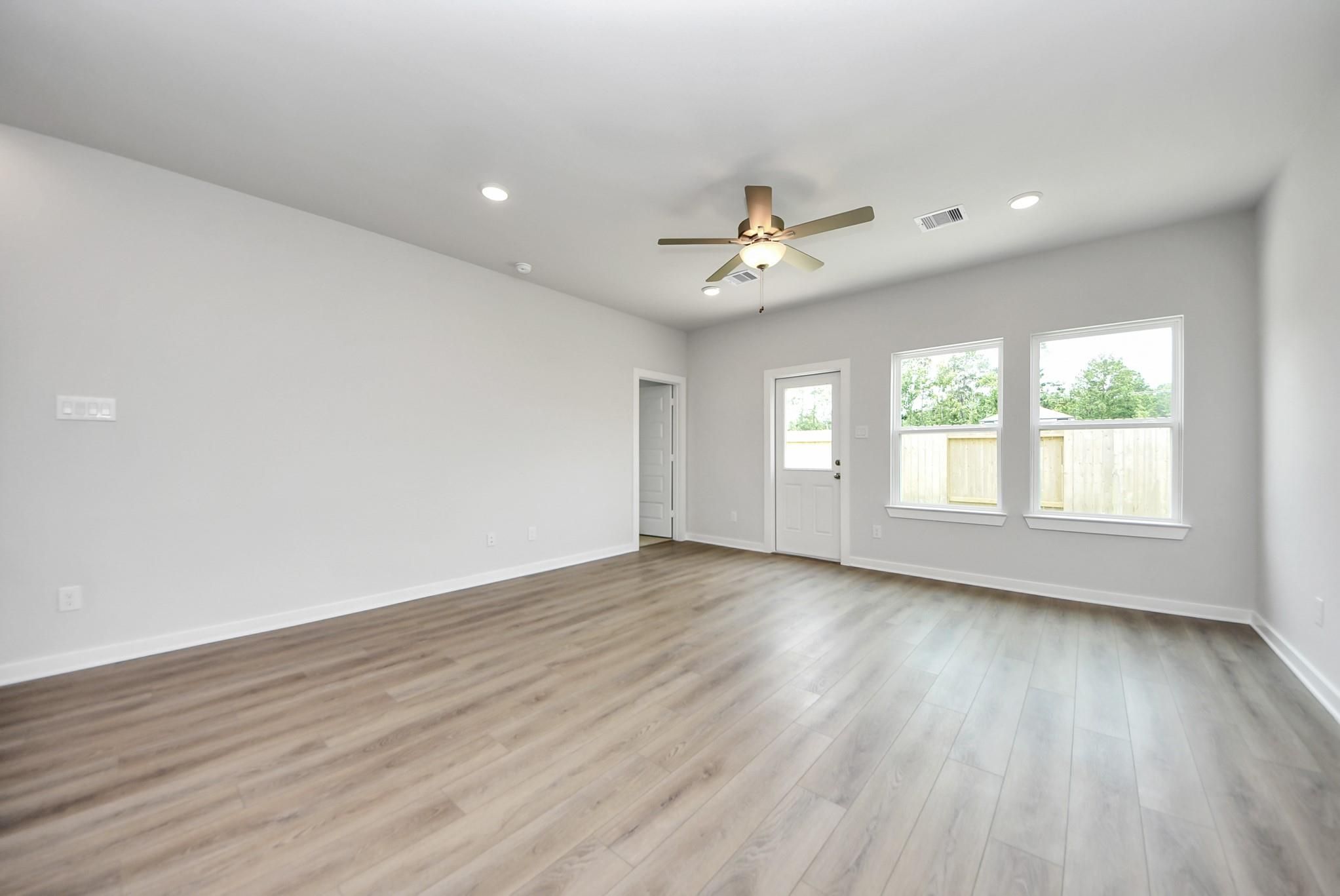 Spacious, light-filled living area with wood-look flooring in The Blanco E floor plan at The Villages at WestPointe.