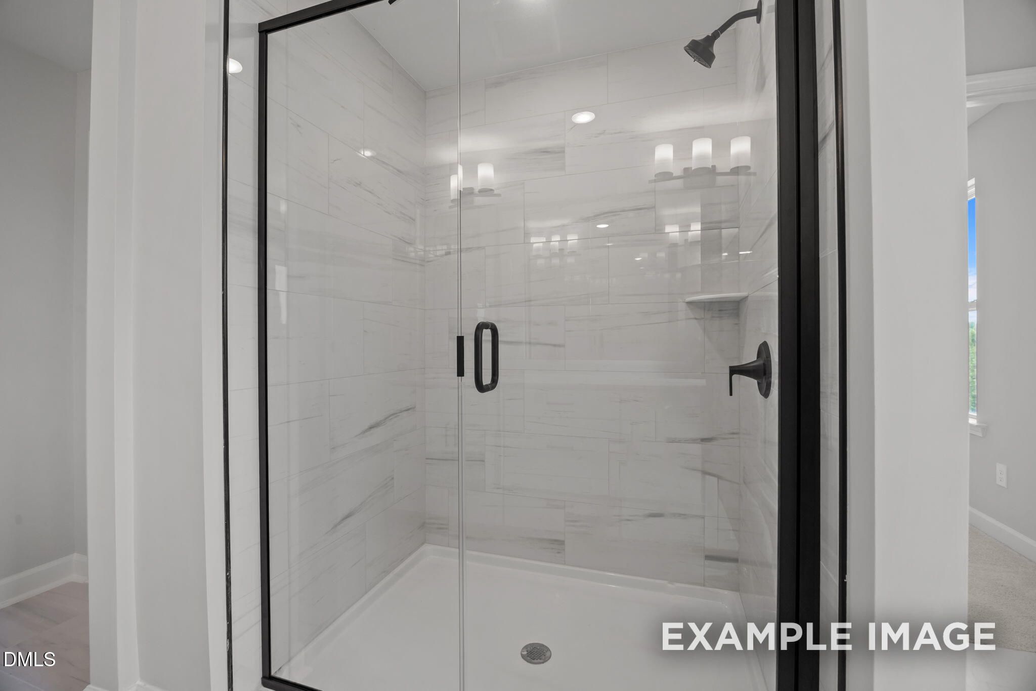 Frameless glass walk-in shower with marble tile and matte black fixtures in Davidson Homes The Beech bathroom, Wendell Ridge
