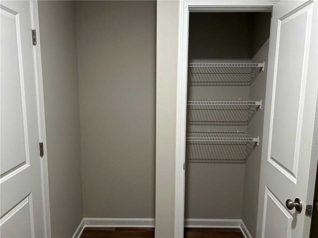 Spacious walk-in closet with wire shelving and neutral walls in The Washington 3-bedroom home, Davidson Homes, Phenix City, Alabama