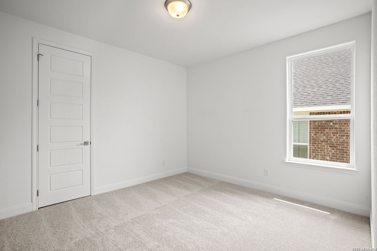 Bright, carpeted secondary bedroom in The Lanier G floor plan at The Reserve at Potranco Oaks in Castroville, Texas.