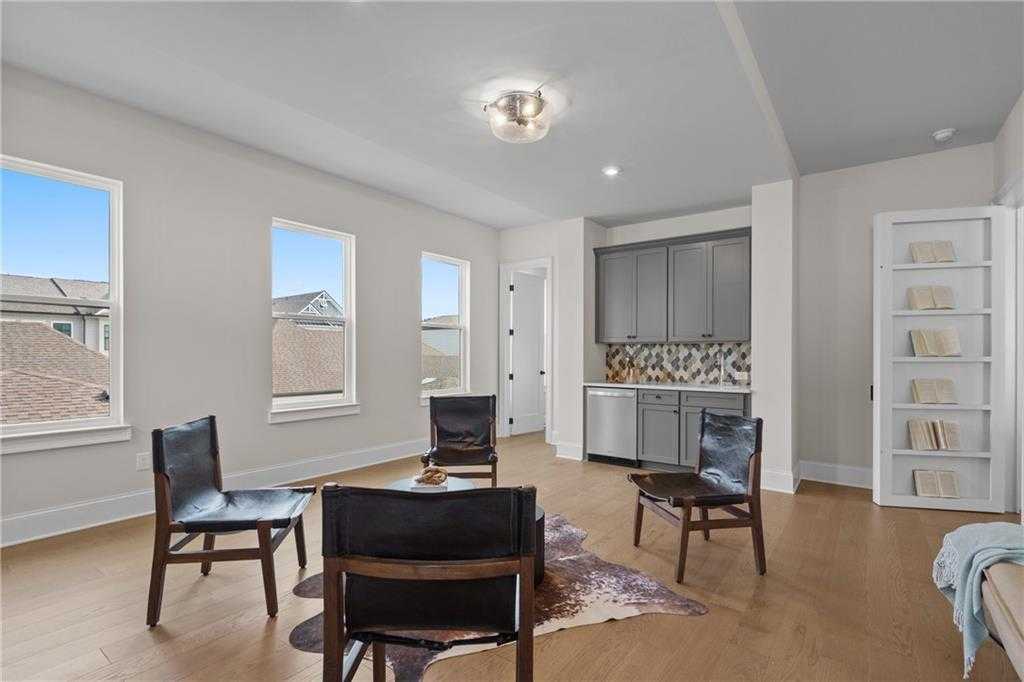 Elegant home office with black leather chairs, cowhide rug, built-in bookshelves, and mosaic backsplash in Davidson Homes Seaside B, Woodstock, GA