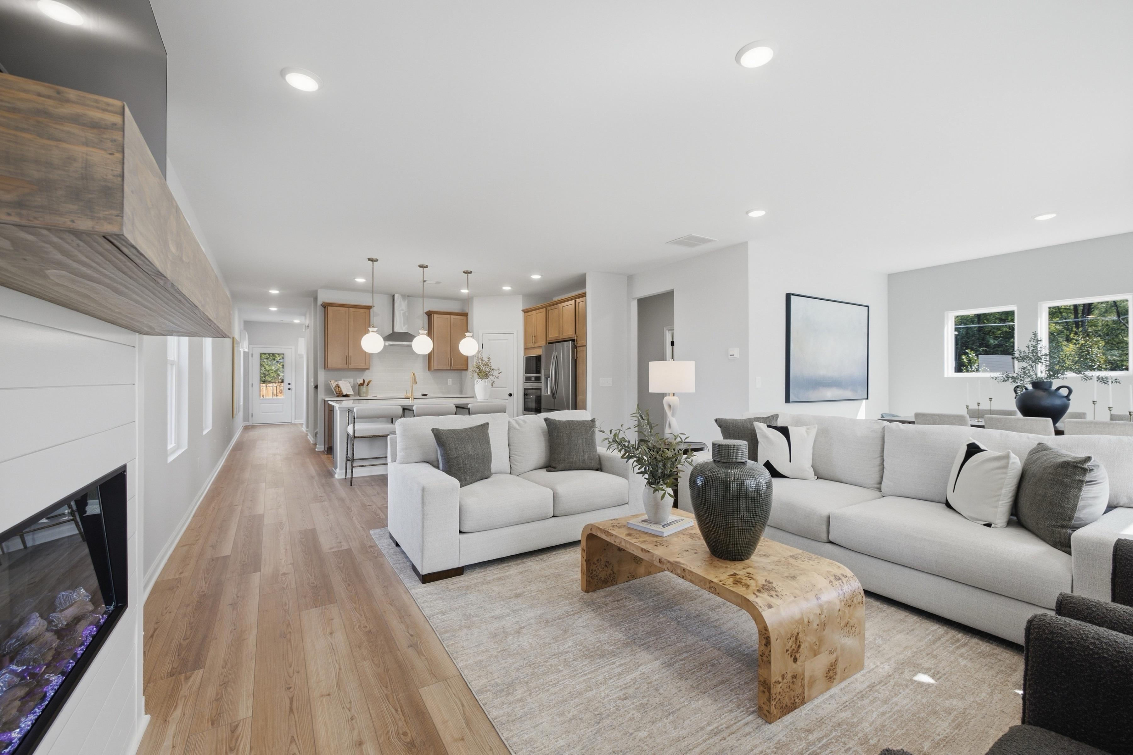 Open-concept living room and kitchen at Greene Farm in Cartersville, Georgia by Davidson Homes with hardwood floors and fireplace