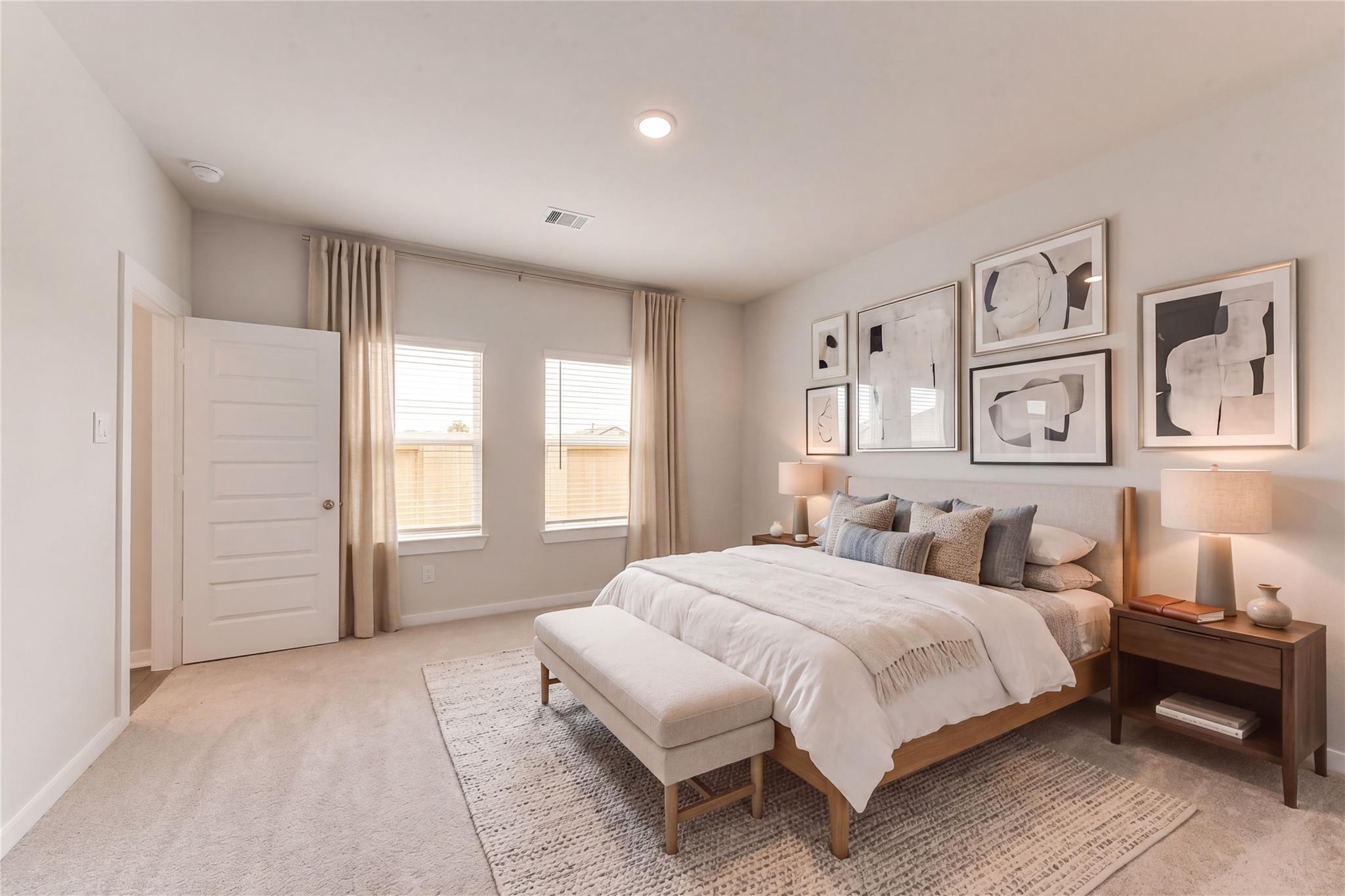 Elegant master bedroom with king bed, abstract art, beige curtains, and wood nightstands in Davidson Homes Sabine F, Dayton, Texas