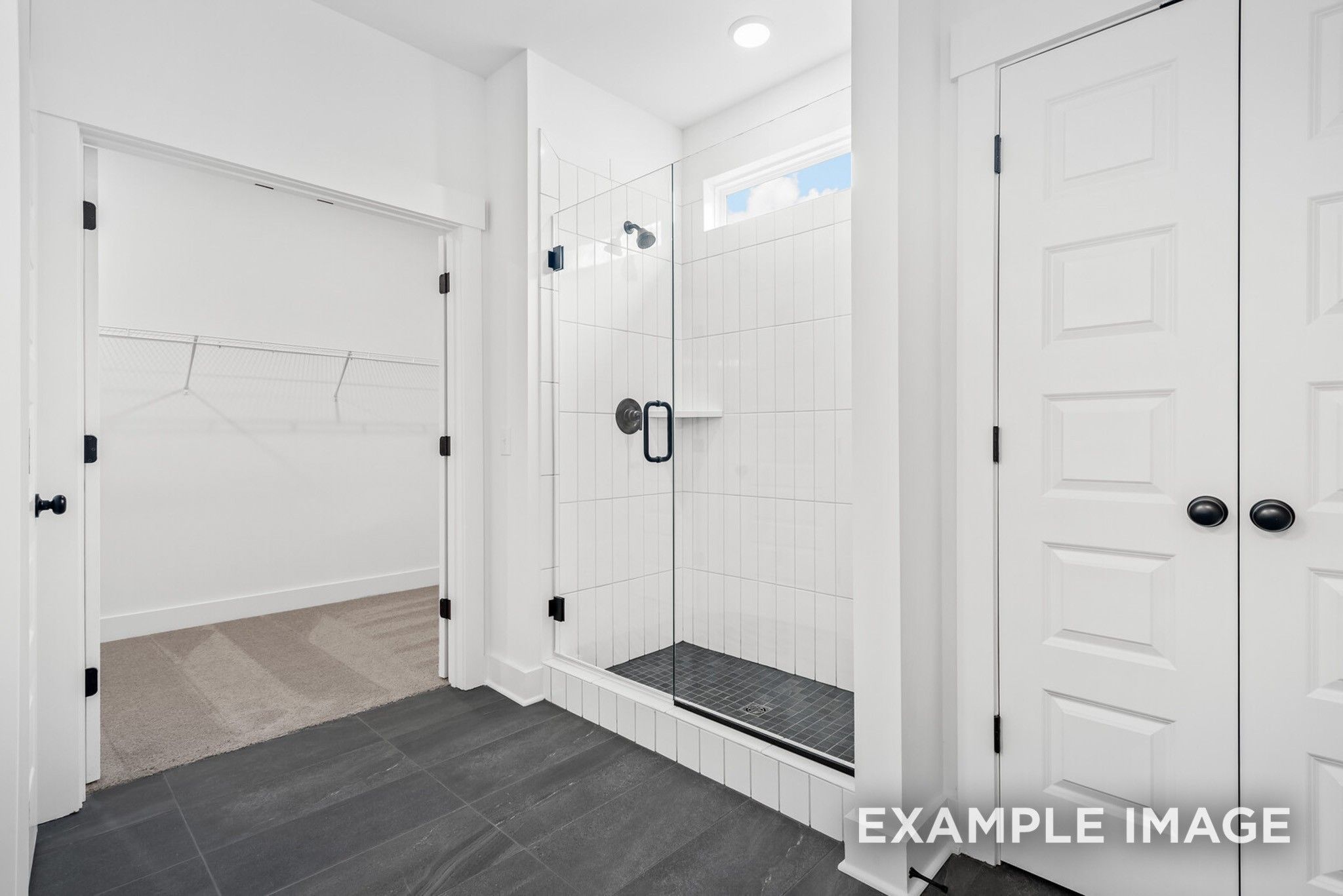 Modern master bathroom with frameless glass shower and walk-in closet in Davidson Homes Ridgeport C, Gallatin, TN