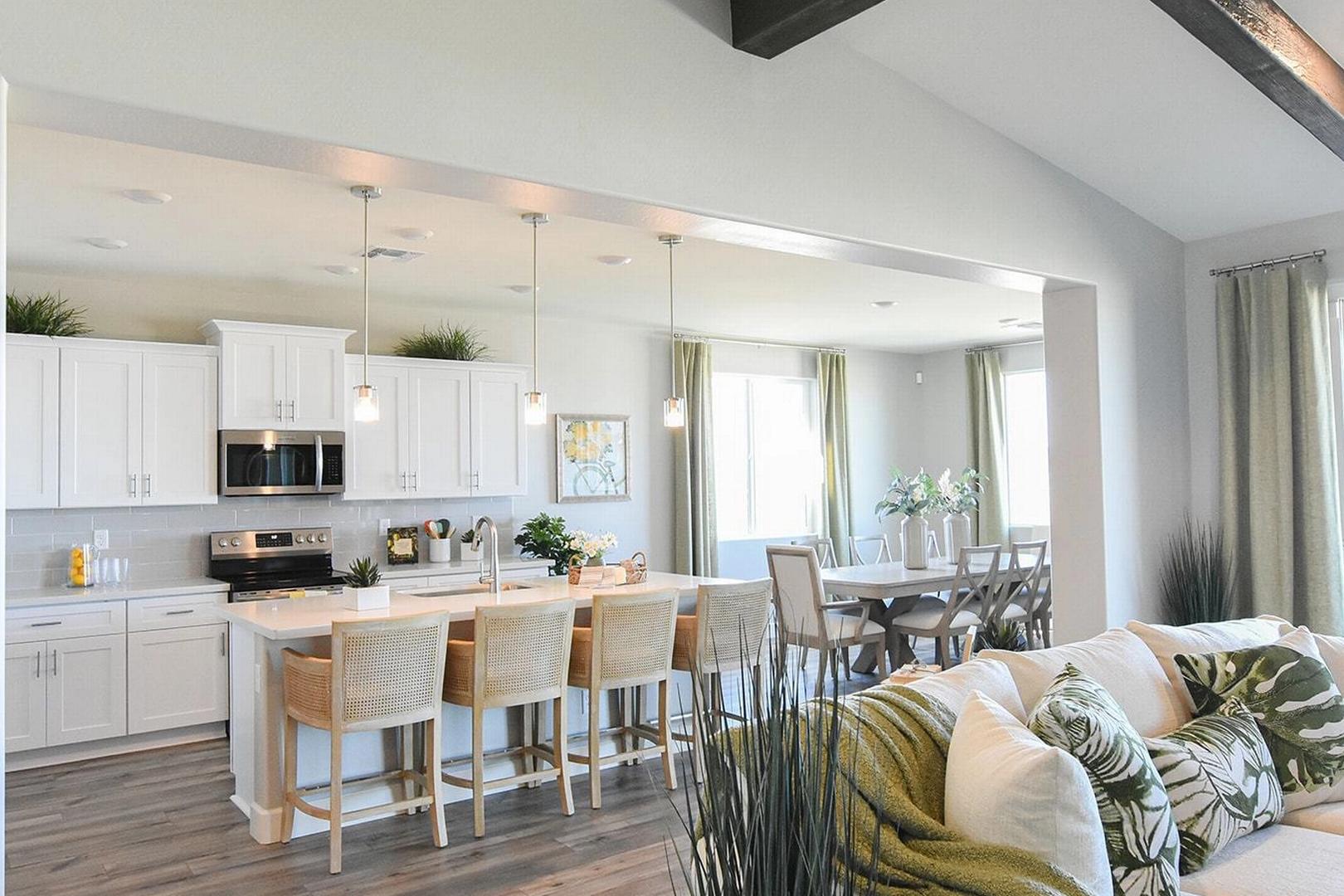 Modern open-concept kitchen and dining in Morningstar Prescott Valley AZ home by Evermore Homes with white cabinets, island, hardwood floors