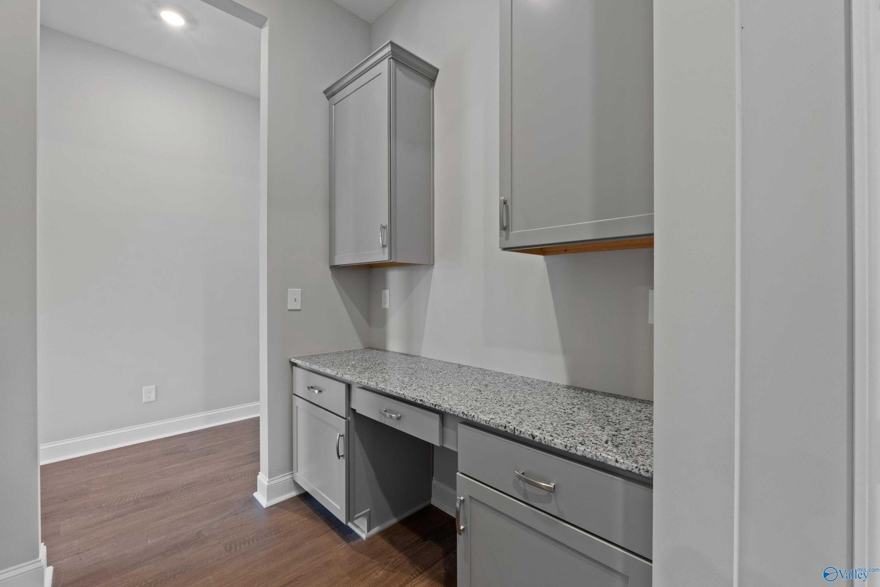 Modern built-in workspace with gray shaker cabinets and granite countertop in Davidson Homes The Arcadia, Huntsville AL