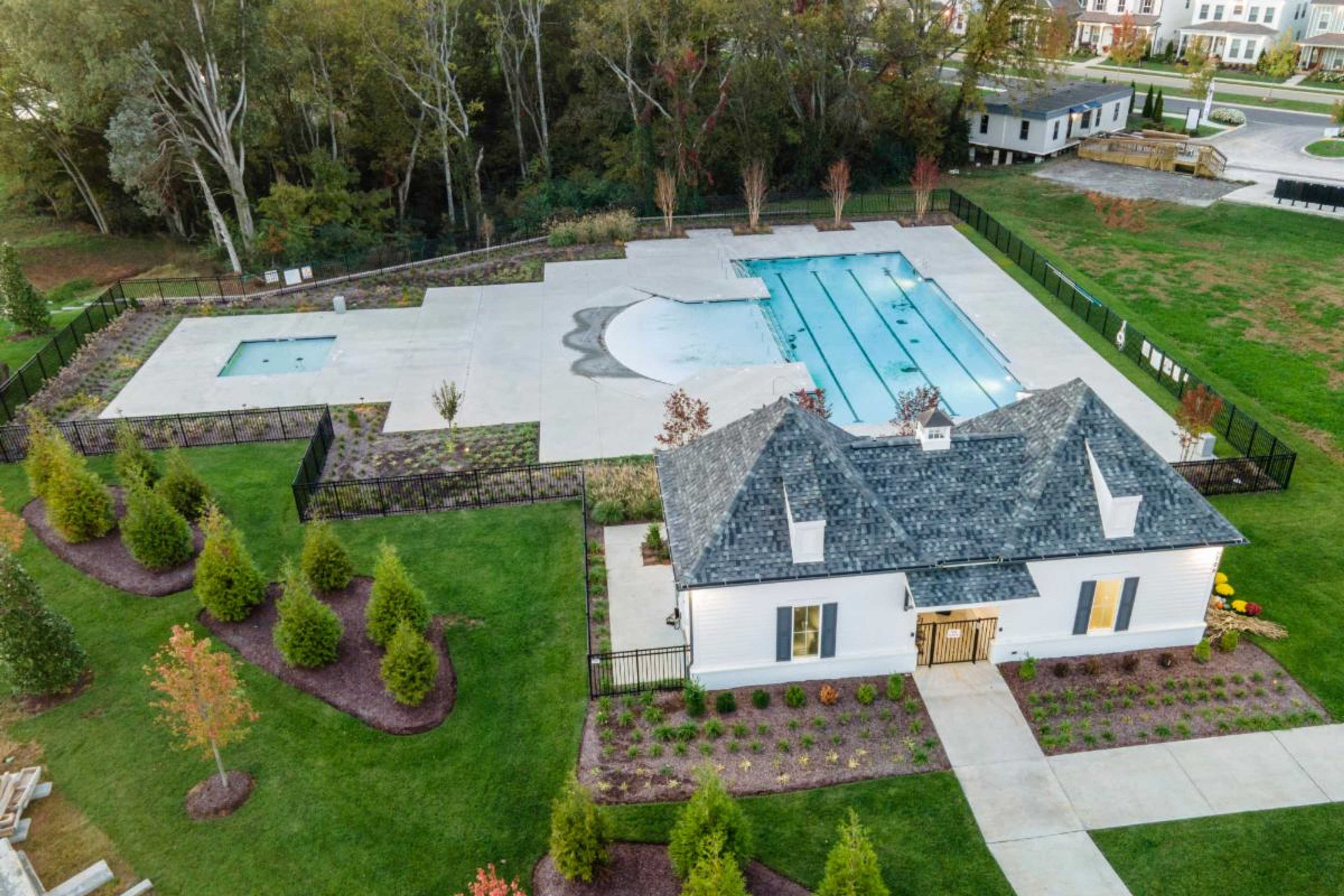 Resort-style pool with lap lanes and hot tub at Shelton Square in Murfreesboro TN, featuring white clubhouse and landscaped deck