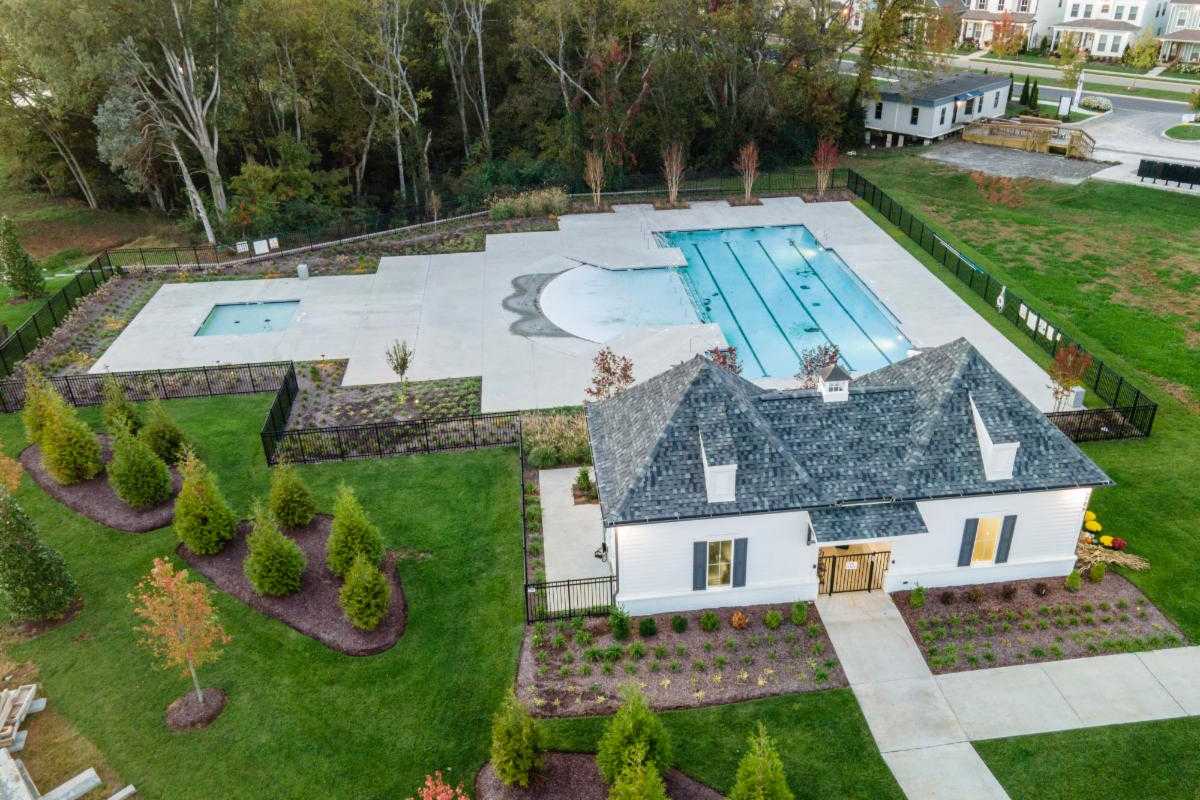 Resort-style pool with lap lanes and hot tub at Shelton Square in Murfreesboro TN, featuring white clubhouse and landscaped deck
