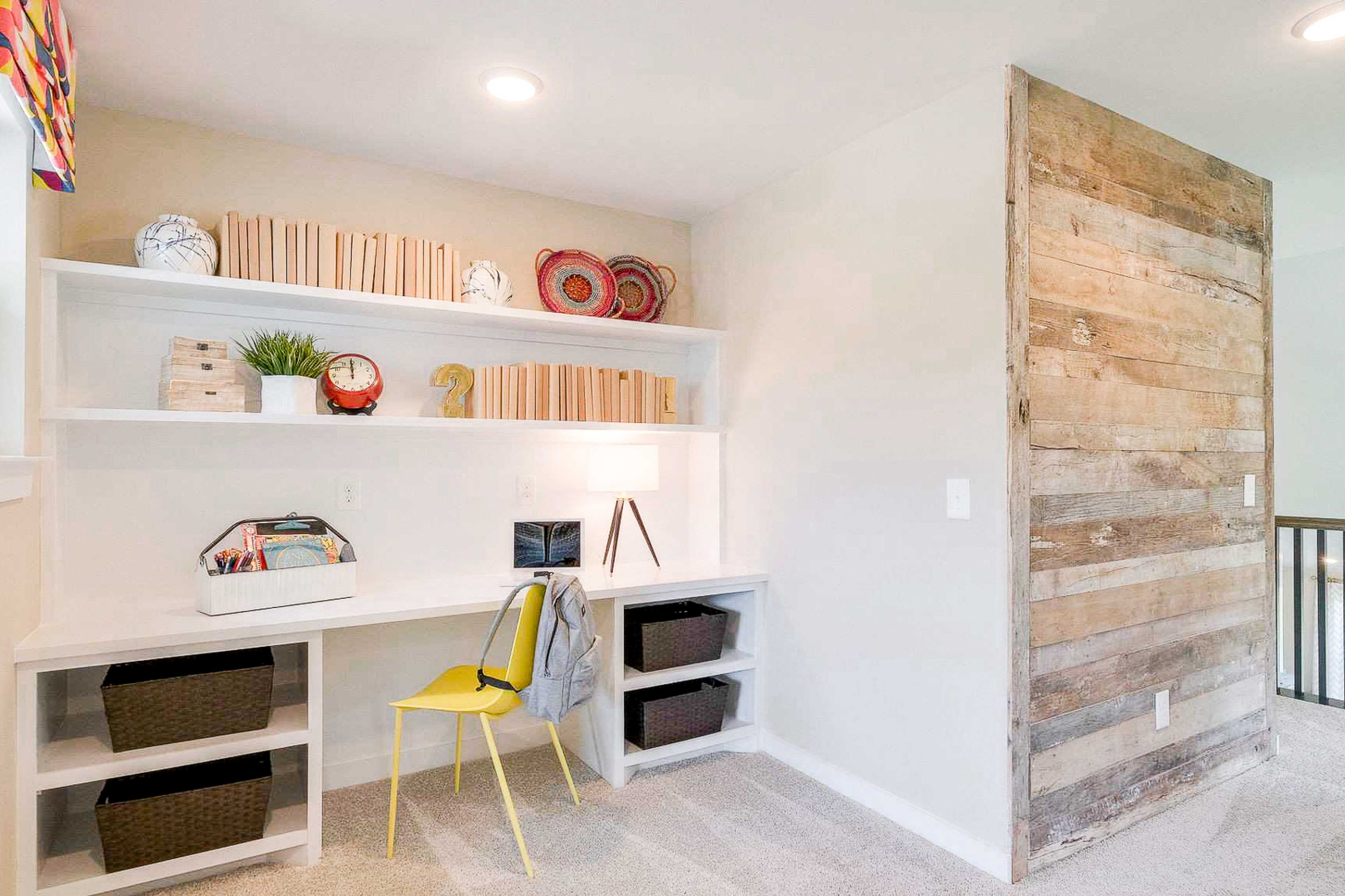 Cozy home office nook at The Meadows in Smyrna TN with built-in shelves, wooden accent wall, desk and yellow chair