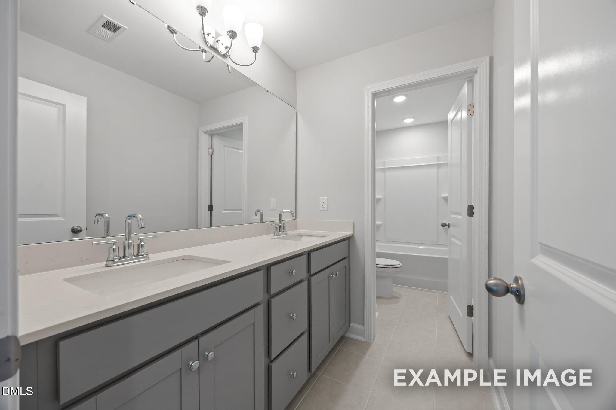 Dual-sink bathroom with gray shaker vanity, quartz countertops, and tub shower combo in Davidson Homes The Beech, Wendell NC