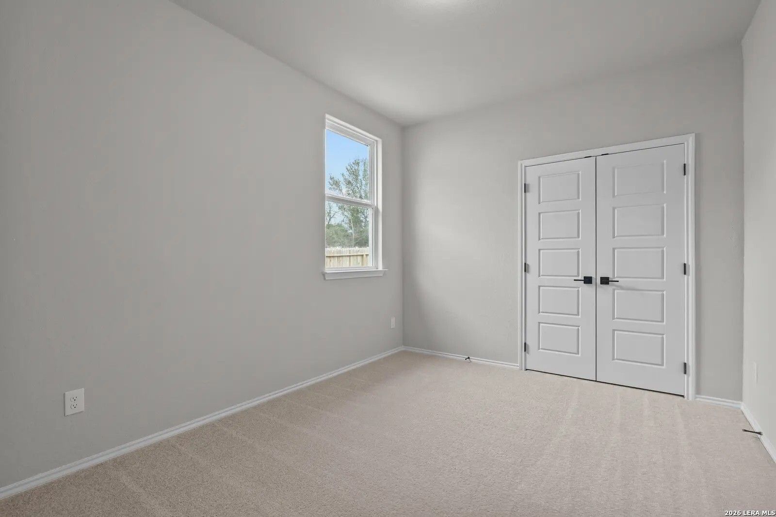 Bright bedroom with walk-in closet and neutral carpet in The Glenwood E floor plan at Comanche Ridge, San Antonio, TX.