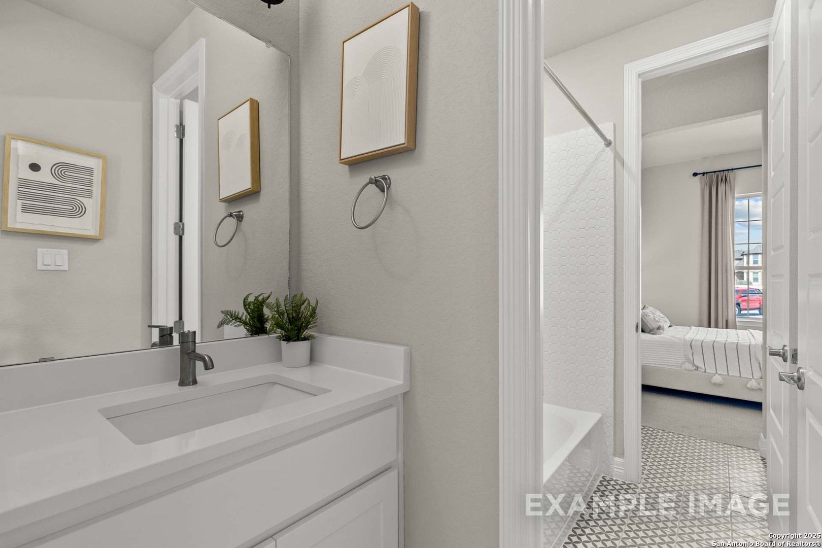 Modern master bathroom with white vanity, walk-in shower, and adjacent bedroom in Davidson Homes The Summerlin B, Castroville, Texas