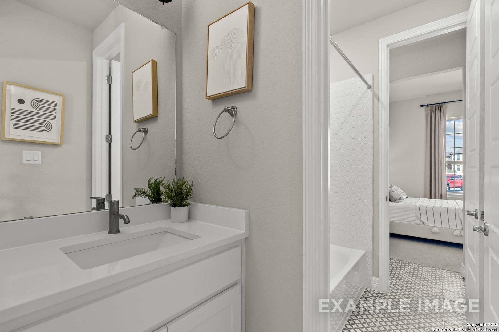 Modern master bathroom with white vanity, walk-in shower, and adjacent bedroom in Davidson Homes The Summerlin B, Castroville, Texas