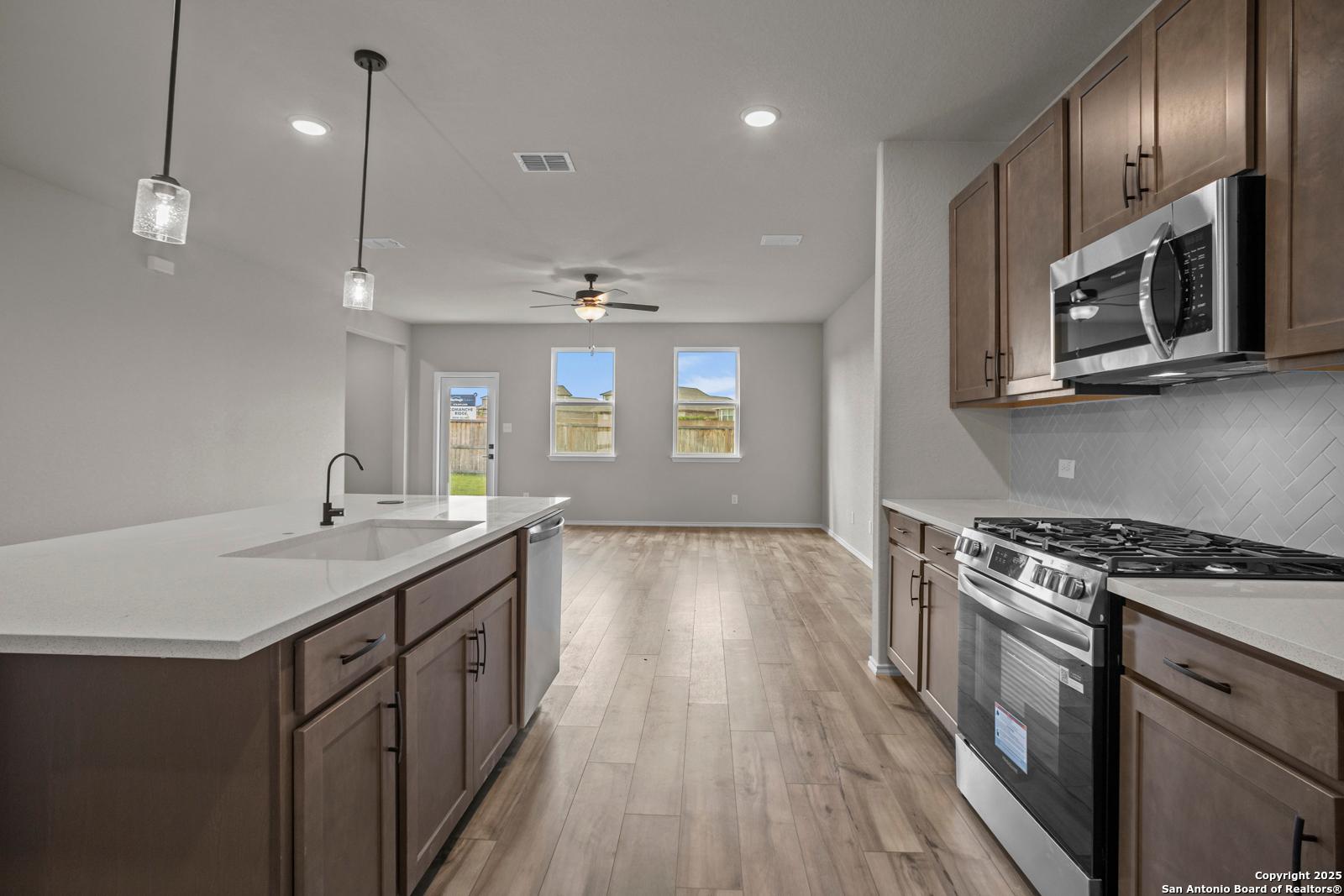 Modern kitchen island with stainless steel appliances and open-concept living in 4-bedroom Davidson Homes The Douglas F, San Antonio