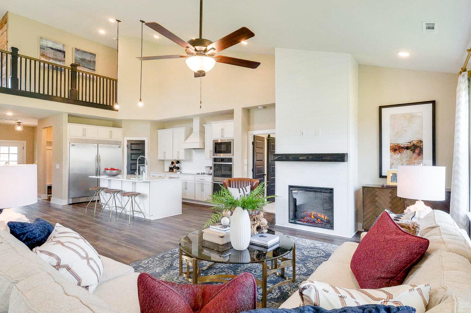 Spacious open-concept kitchen and living room at The Meadows in Smyrna TN with white island, gas fireplace, and hardwood floors