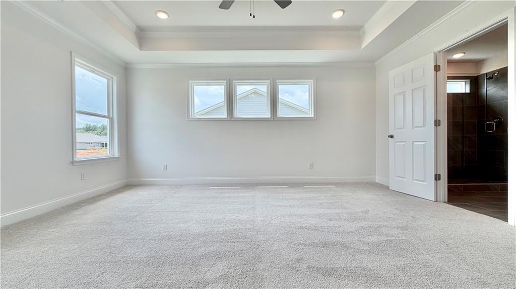 Spacious primary bedroom with tray ceiling in The Hickory C floor plan by Davidson Homes at Wehunt Meadows, Hoschton, GA.