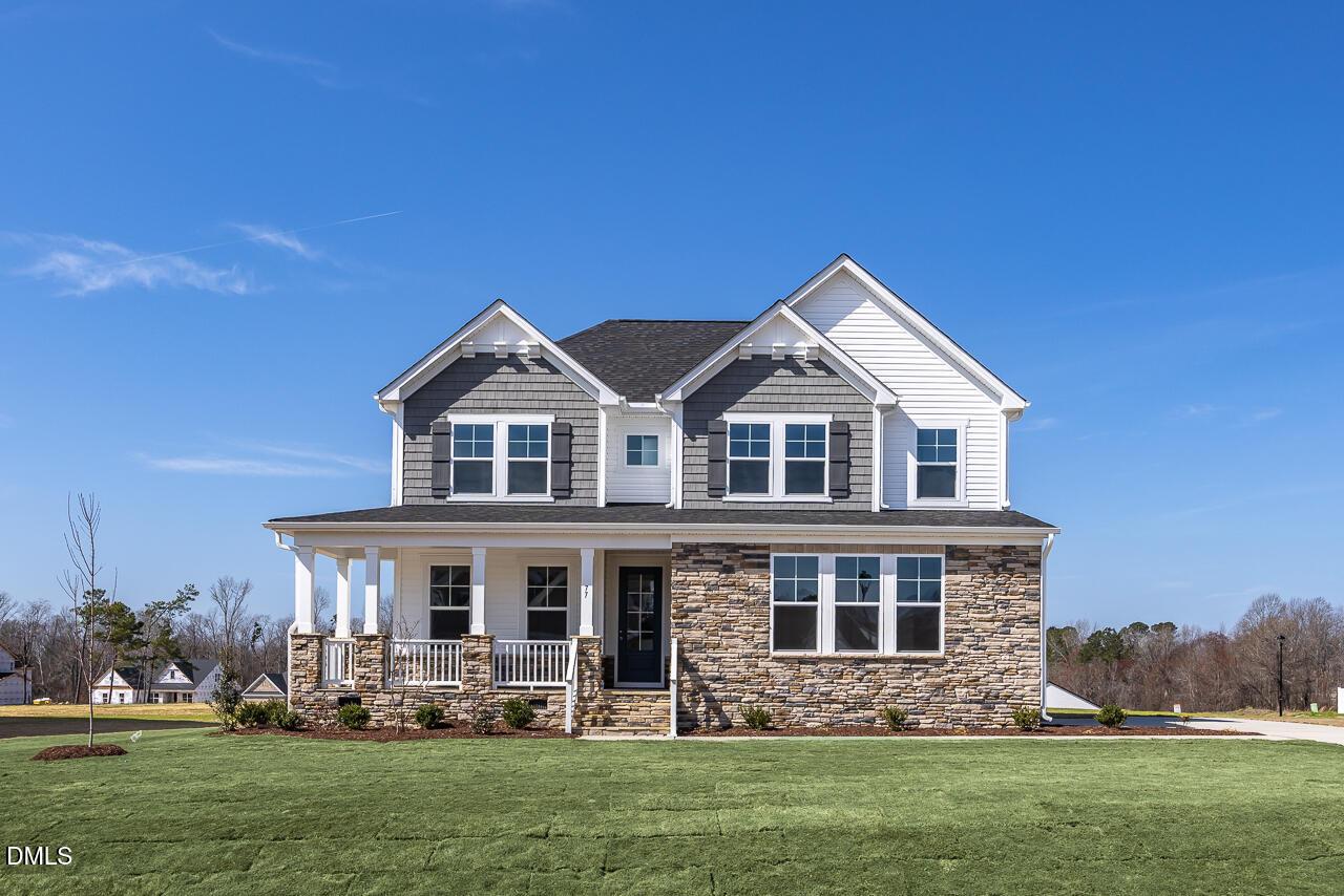 Two-story 5-bedroom Davidson Homes Willow G with gray siding, stone accents, covered porch in Tobacco Road, Angier, NC