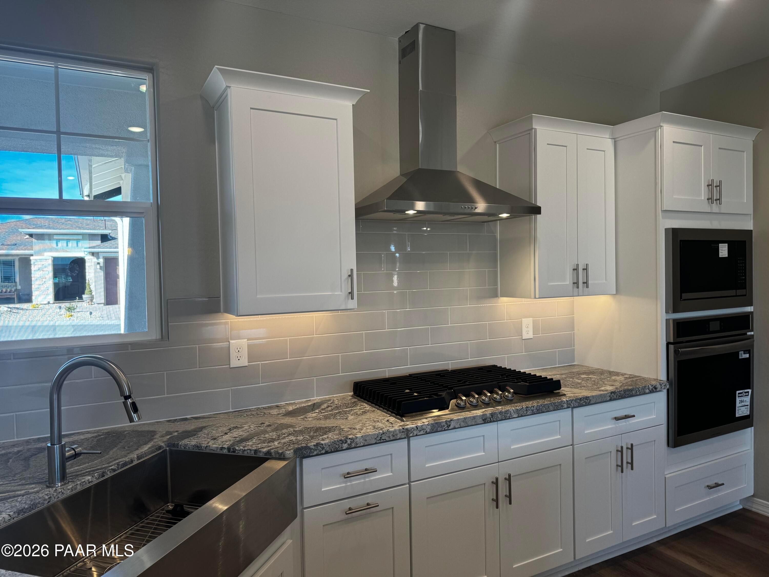 Modern white shaker kitchen with granite counters, stainless steel appliances, subway tile backsplash in Davidson Homes Daybreak B, Prescott AZ